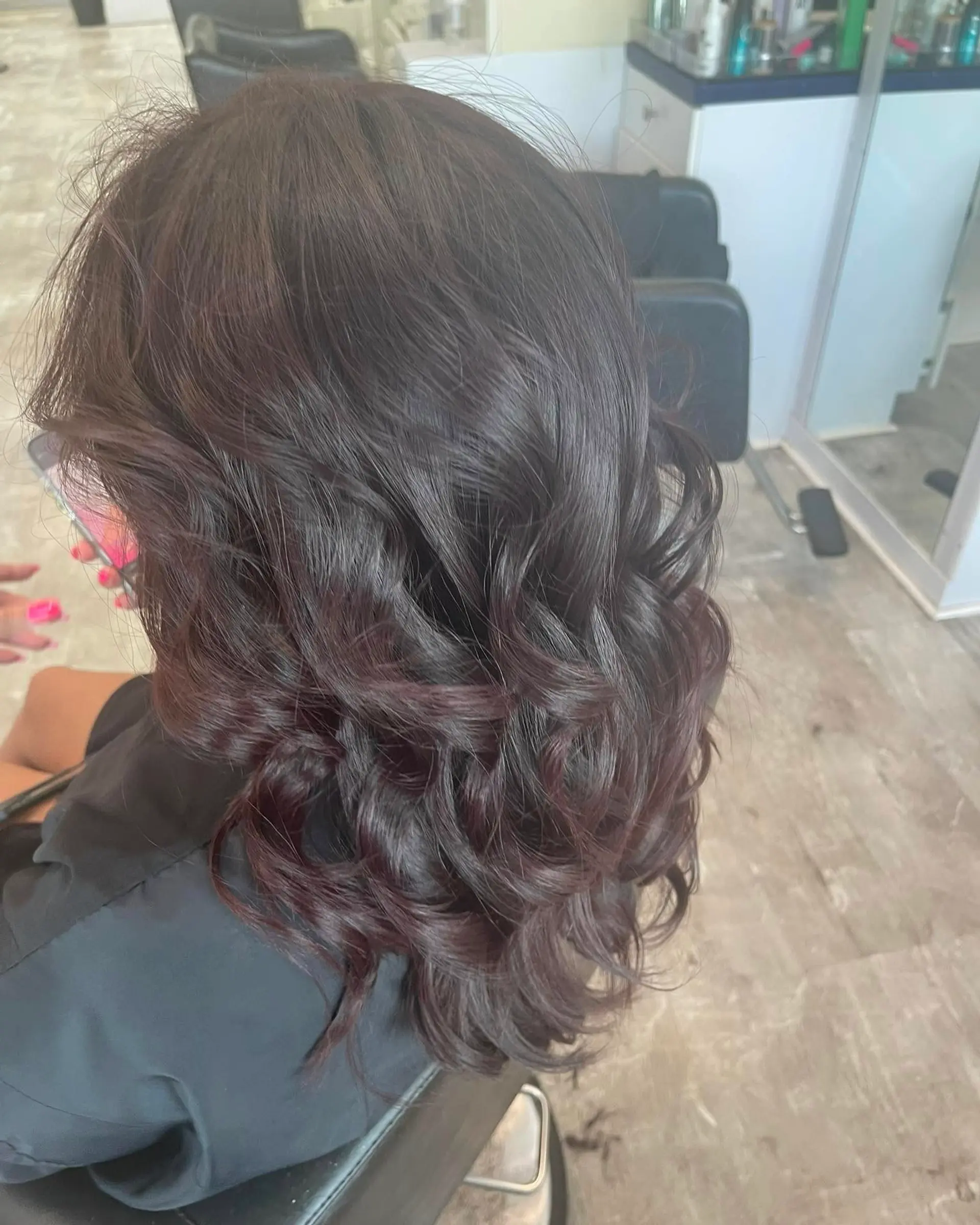 A long, wavy hairstyle featuring a rich burgundy color with romantic waves. 3