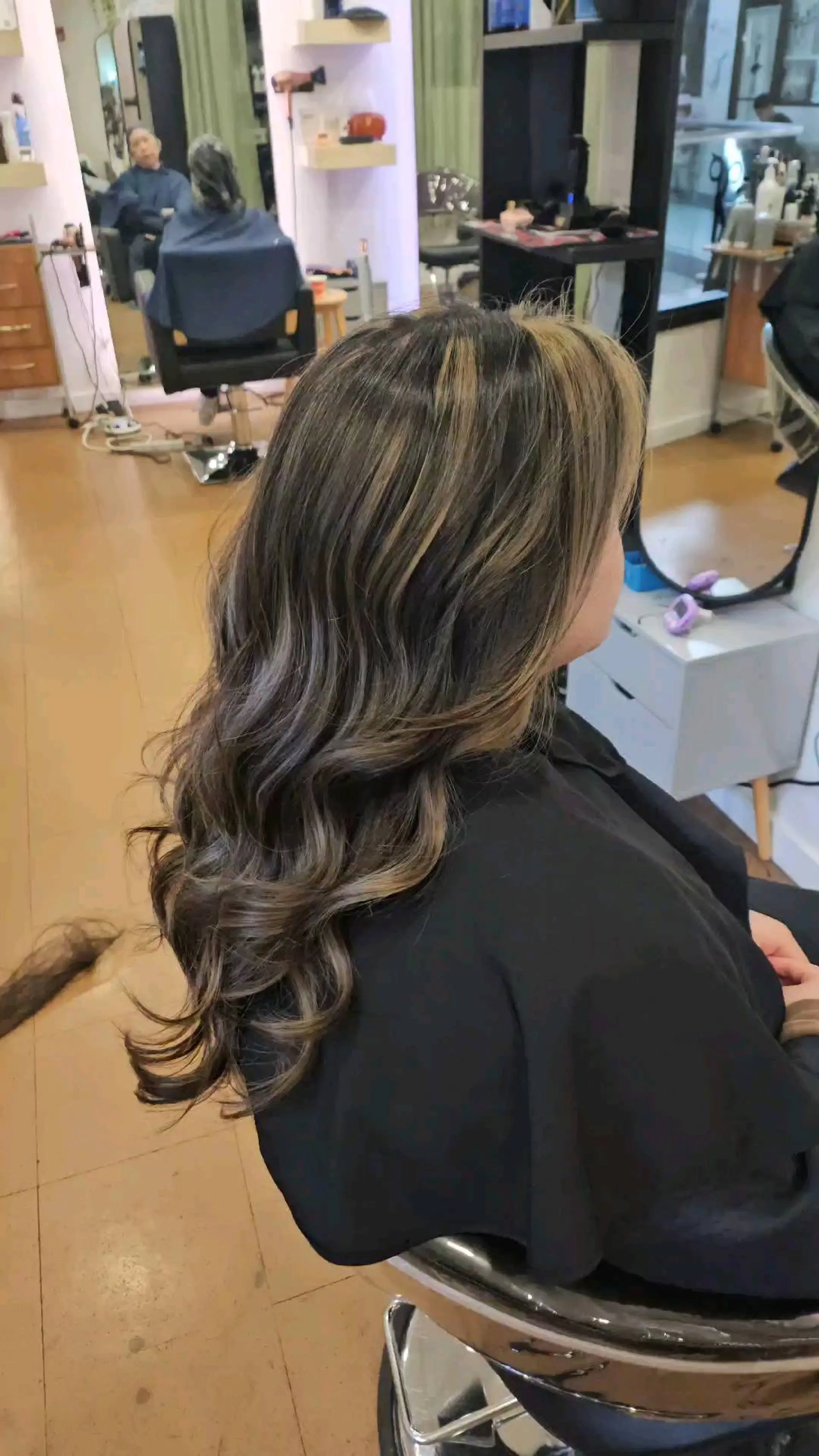 Long layered hair styled with soft, voluminous waves and highlighted with dimensional balayage. 1