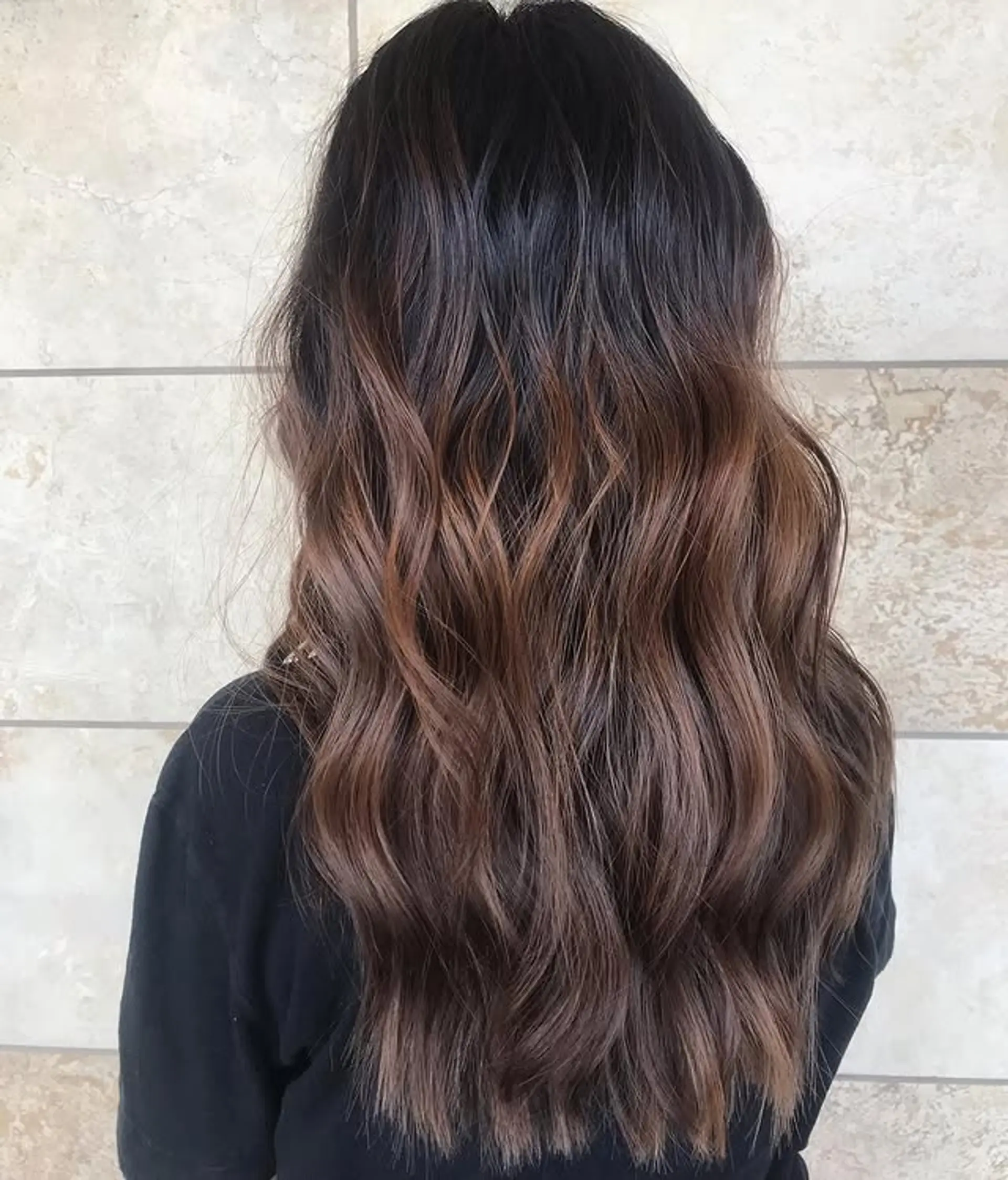 Long, wavy hair with a balayage that blends black roots to chocolate brown ends. 1