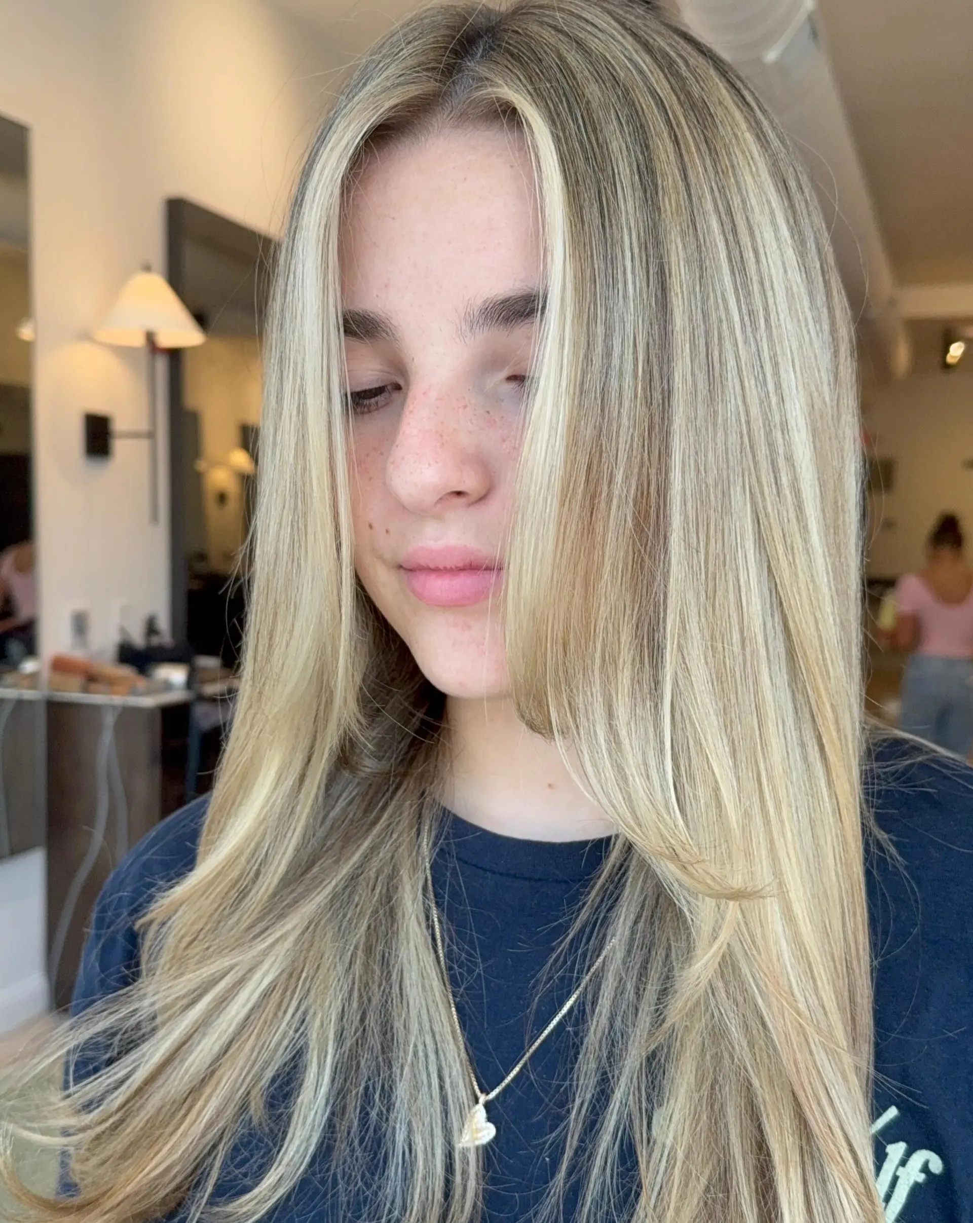 Straight, long butter-blonde hair featuring dimensional highlights and face-framing layers with a center part. 1