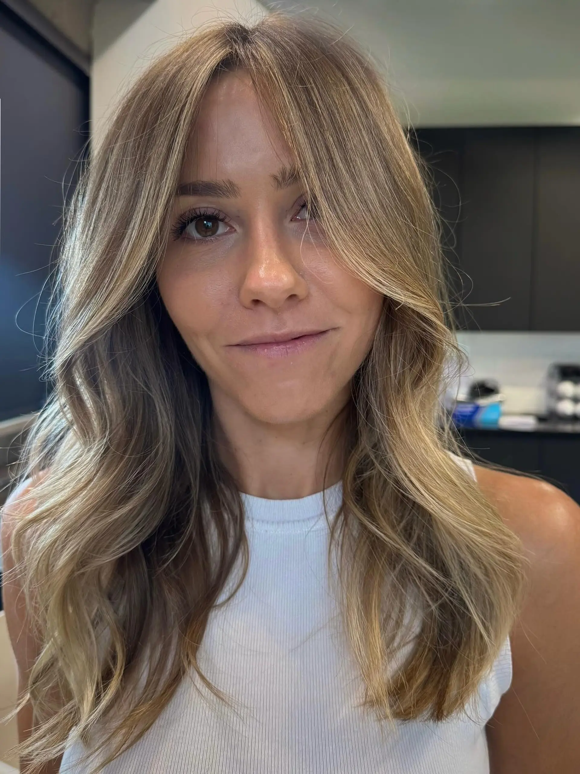 Long, flowing waves with a dimensional golden blonde foilayage, creating a sun-kissed effect with brighter face-framing highlights and subtle layering for movement. 2