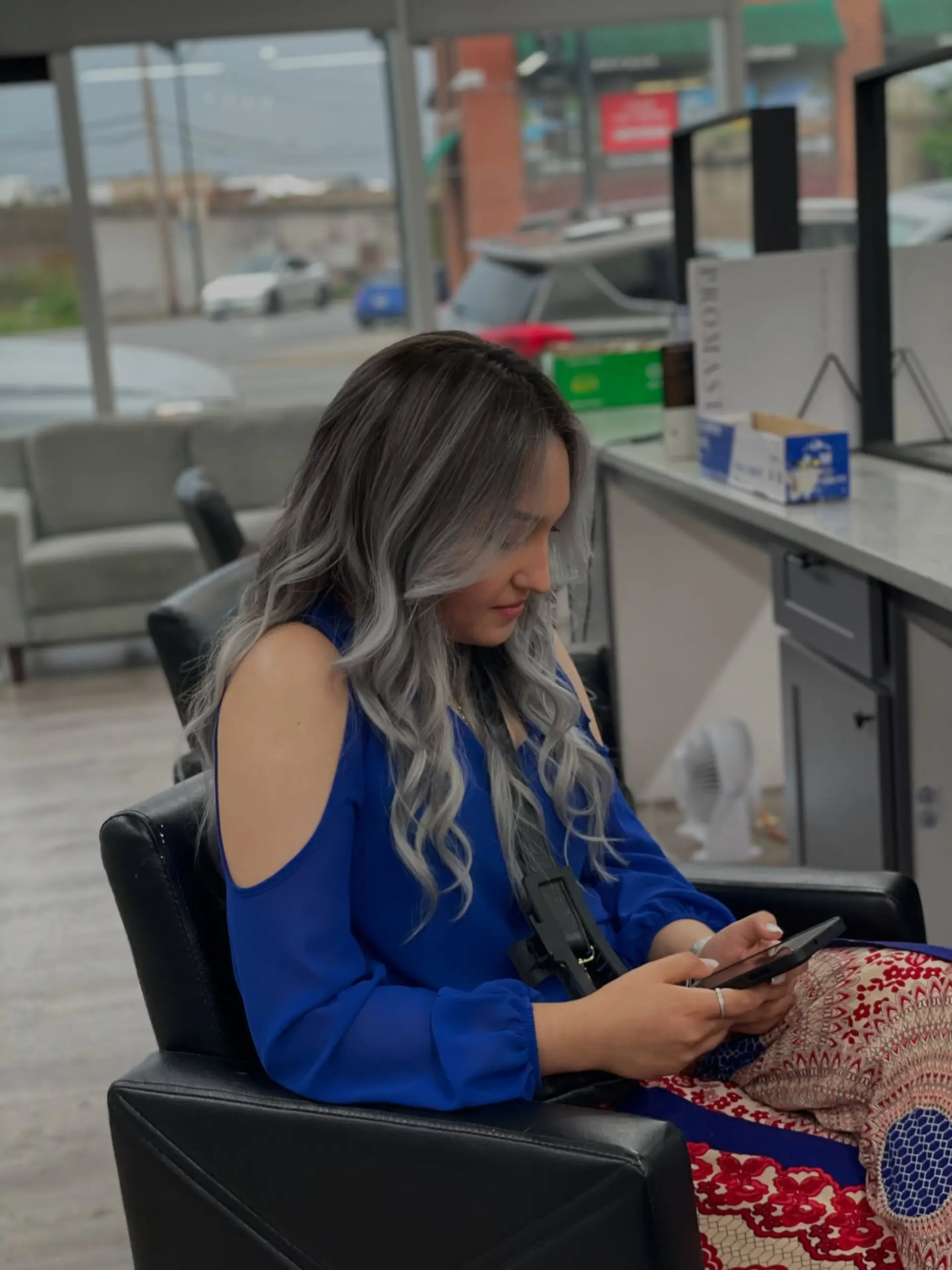 Long, wavy hair styled with a silver balayage, transitioning from dark roots to a trendy silver. 1