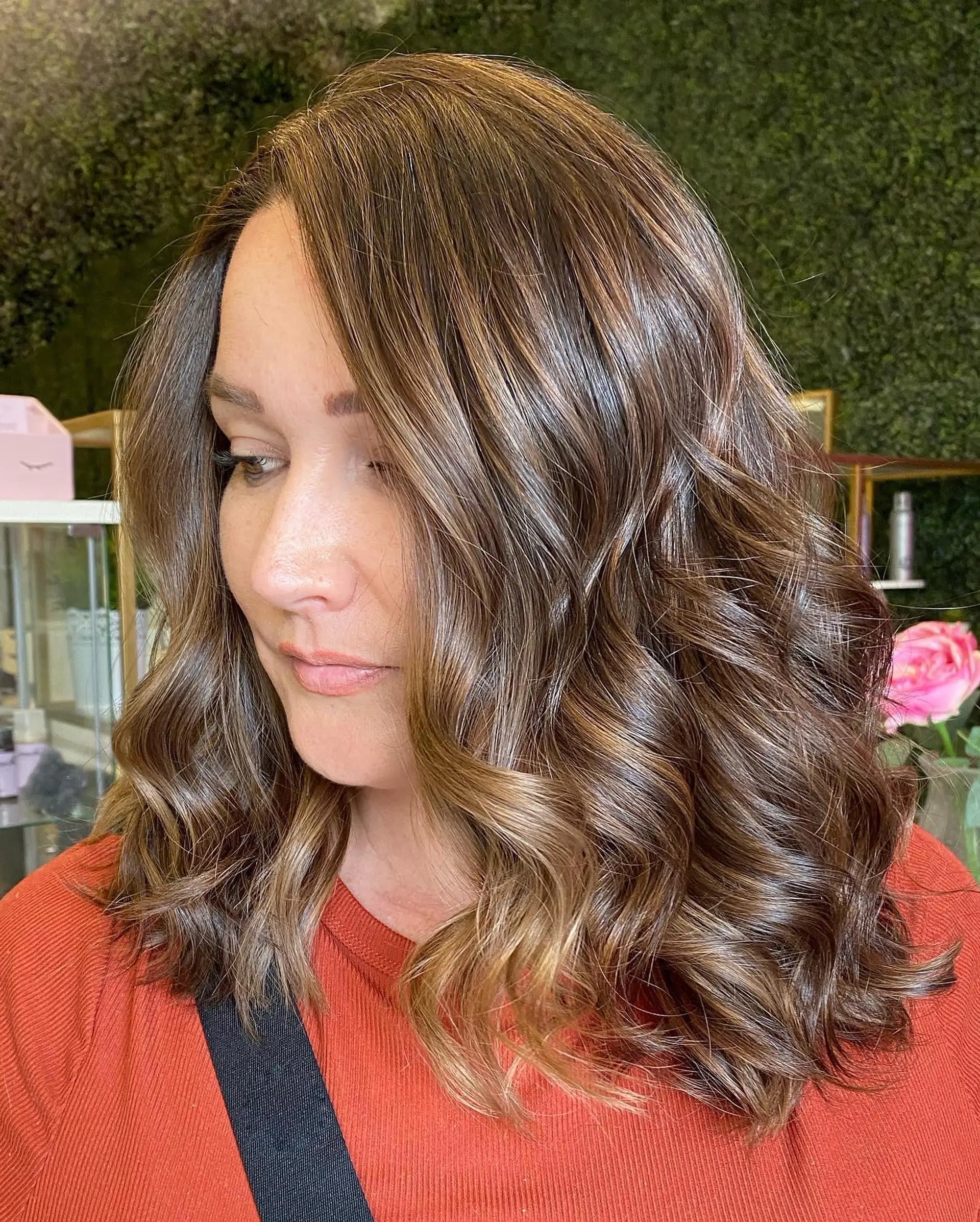 A stylish medium-length wavy hairstyle with soft, bronzed balayage highlights. 1