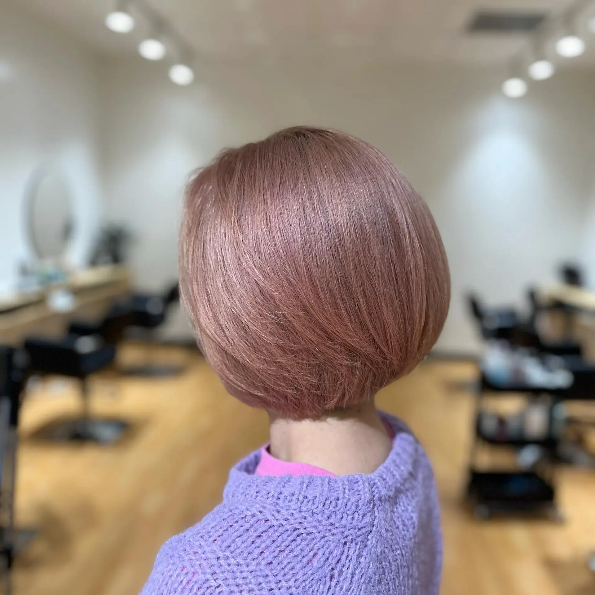 A sleek, rounded chin-length bob cut colored in a soft pastel dusty pink tone. 1