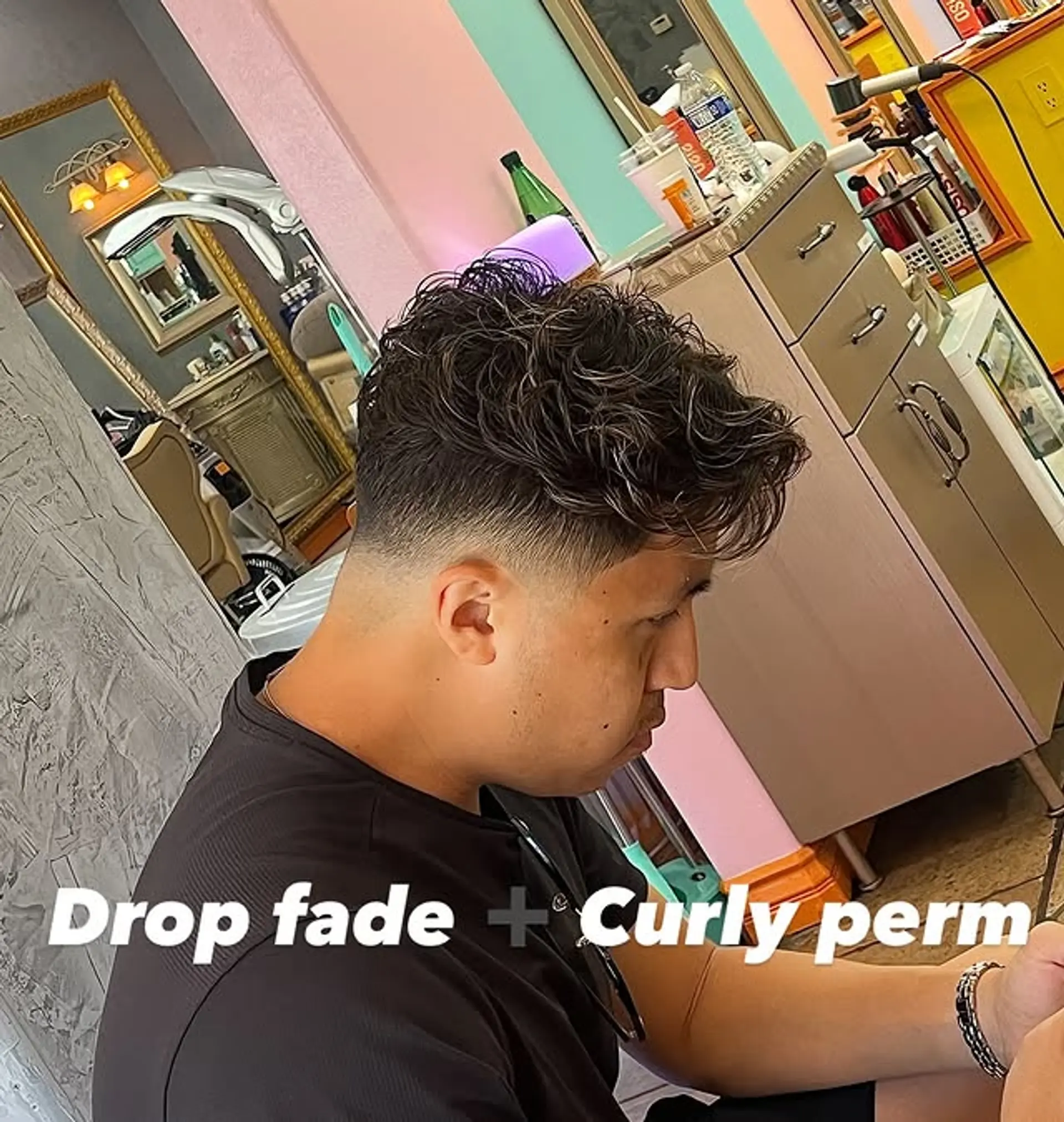 A modern textured haircut with a drop fade and curly perm. 1