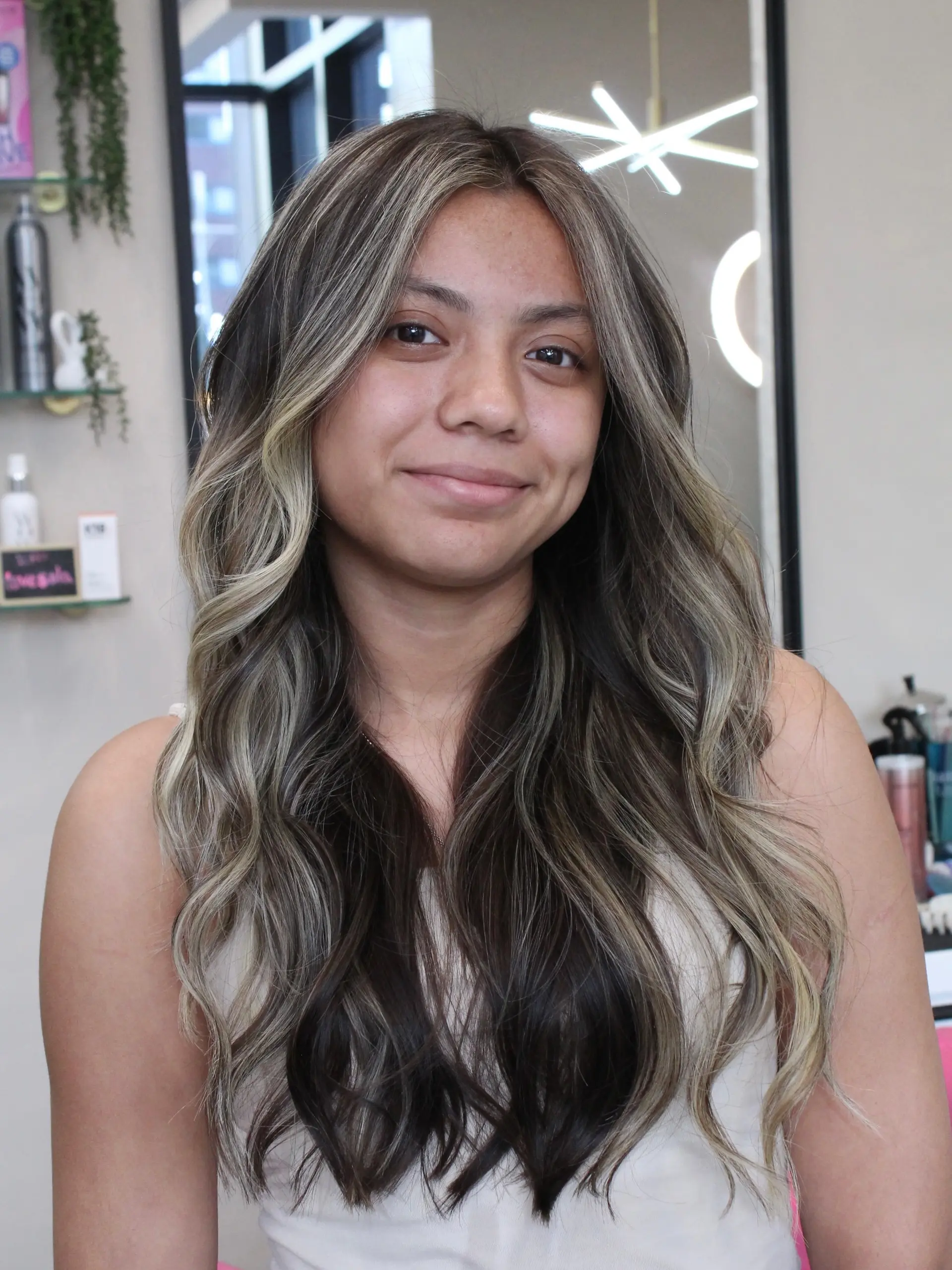 Long dark brown hair styled with bright, cool ash-blonde balayage ribbons and soft, cascading waves. 1