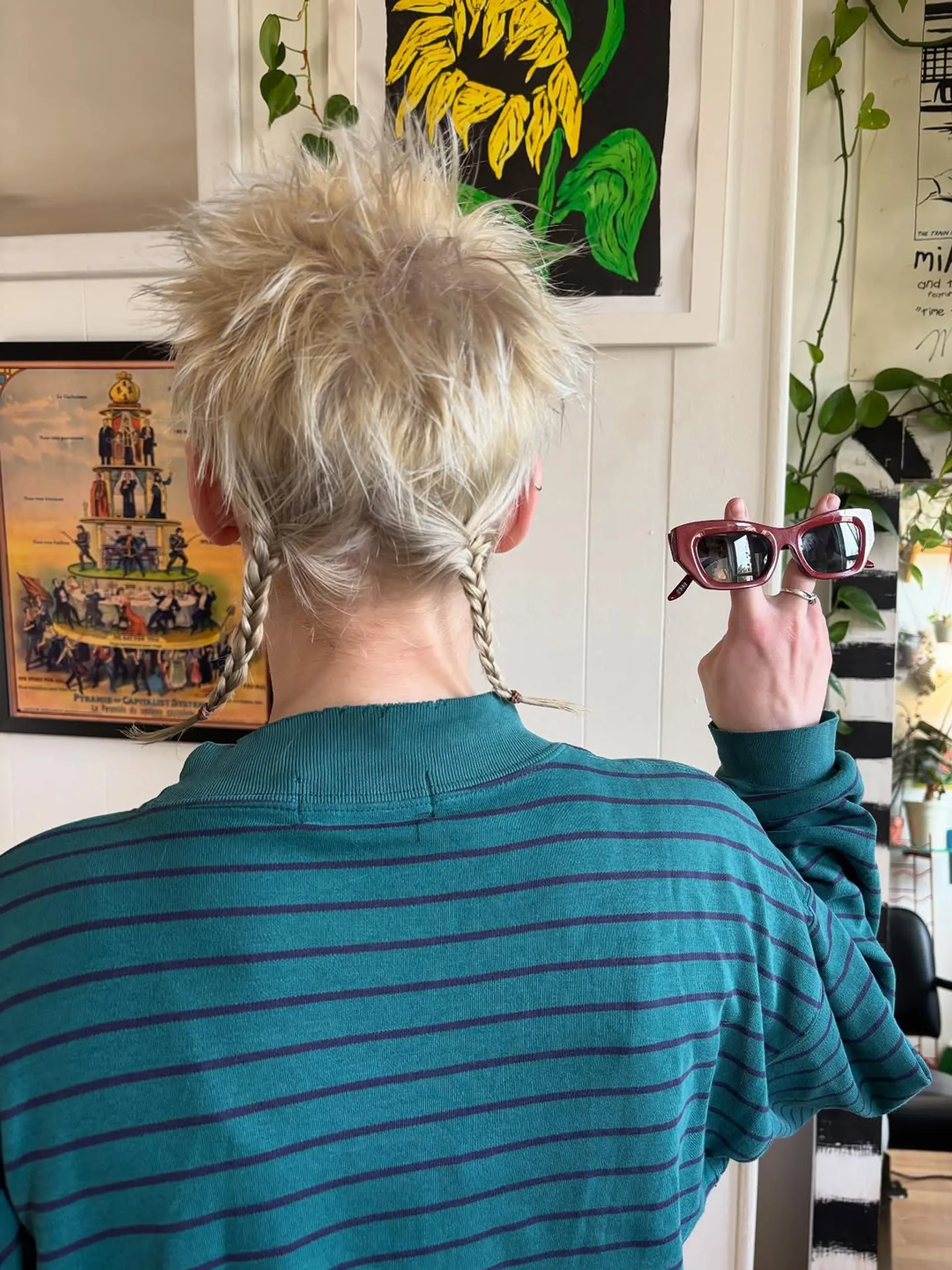 A textured, spiky short cut with length at the nape styled into two small, delicate braids. 1