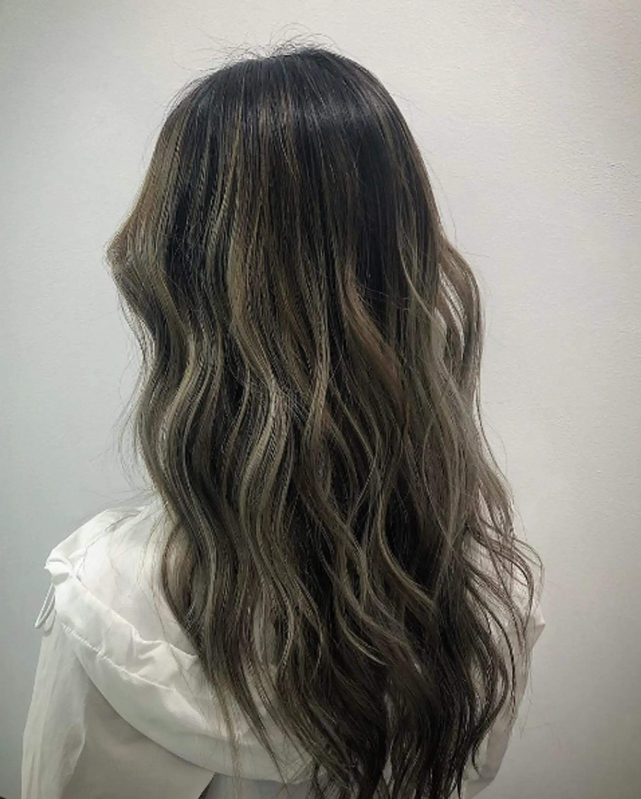 Long, wavy locks with dark brown and ash brown highlights, featuring soft waves and layered ends for a natural and dimensional look.