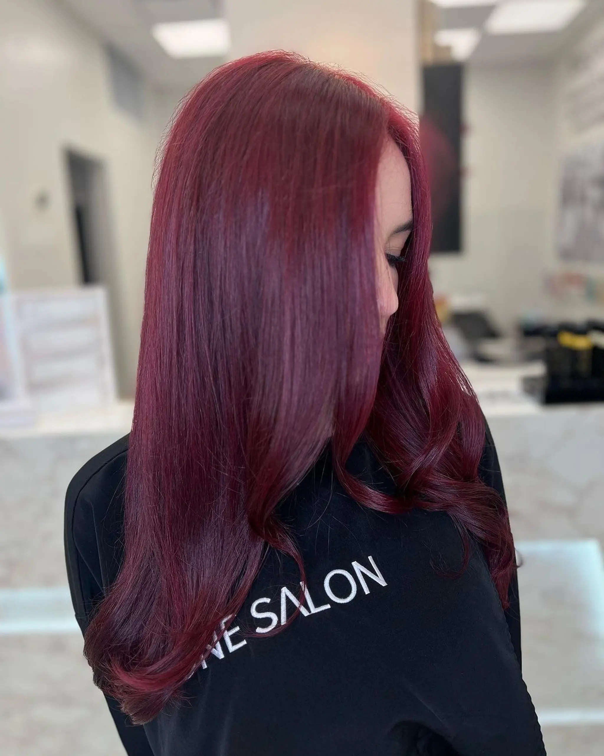 Long, straight hair with a deep burgundy red color, smooth and sleek texture, layered for added depth and movement.
