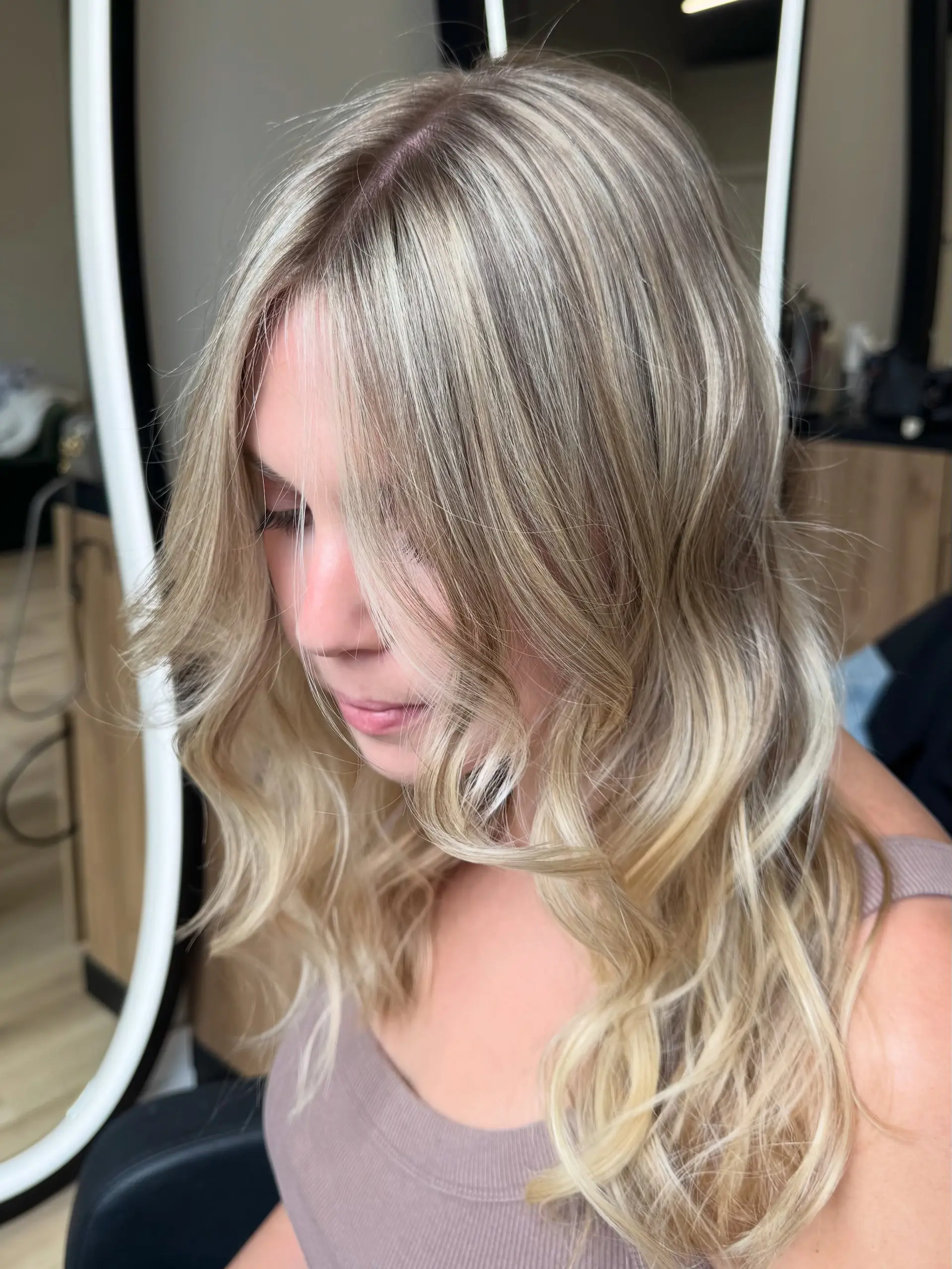 Long dimensional blonde hair styled in soft, loose waves with face-framing layers. 1