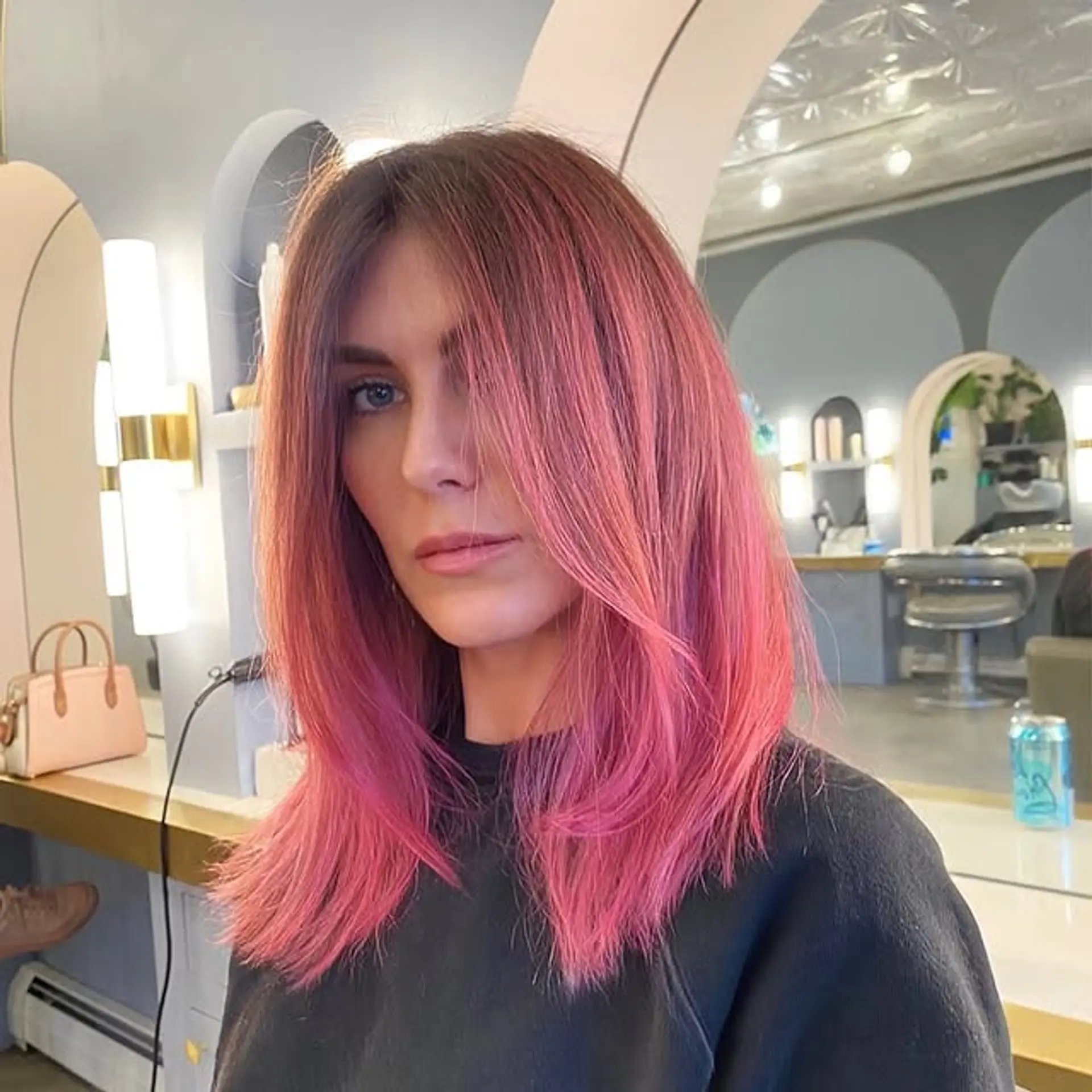A medium-length lob with face-framing layers, featuring a dark root transitioning to pink. 1