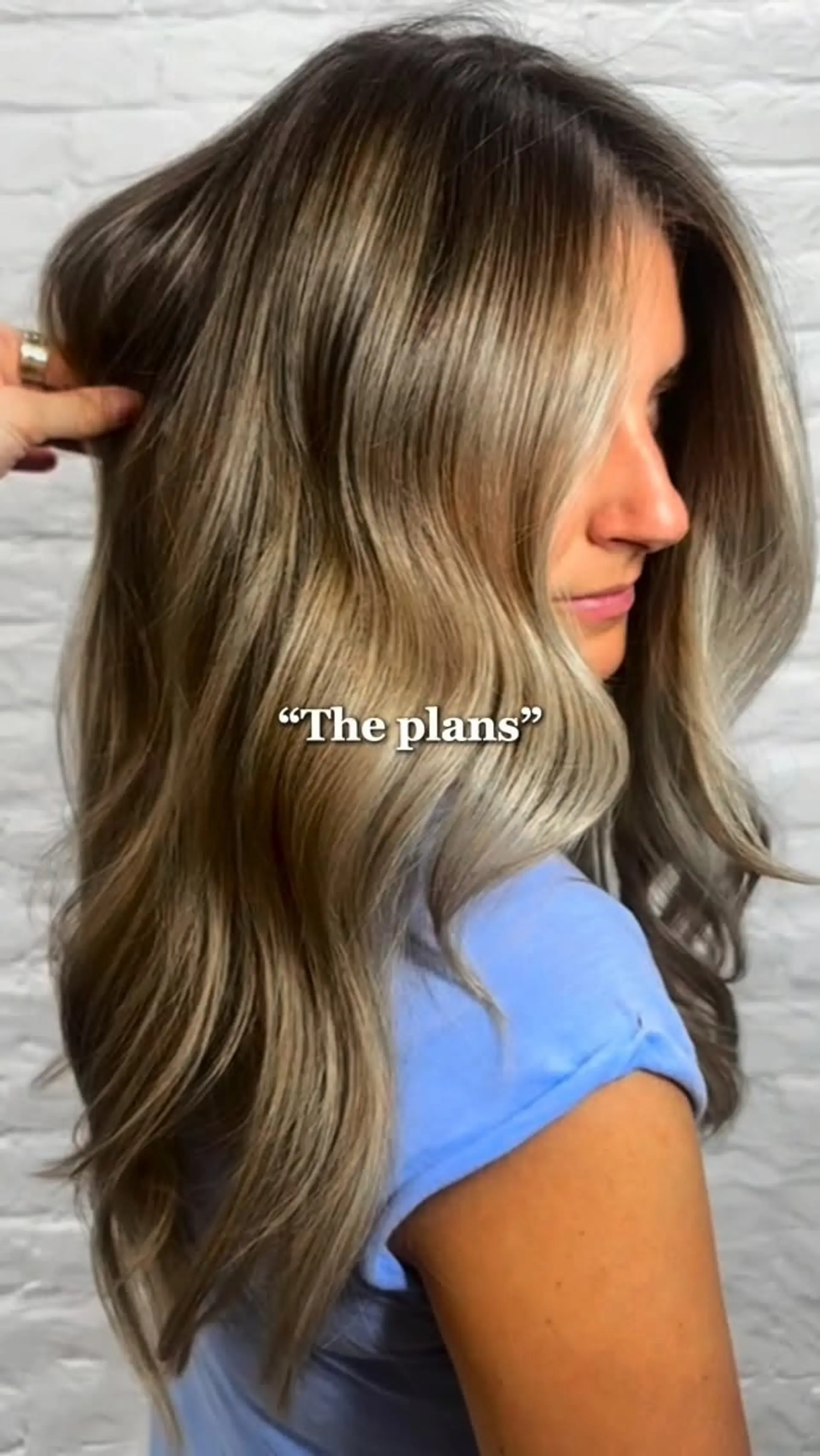 Long dimensional ash blonde hair styled in soft, polished waves with brighter face-framing pieces. 1