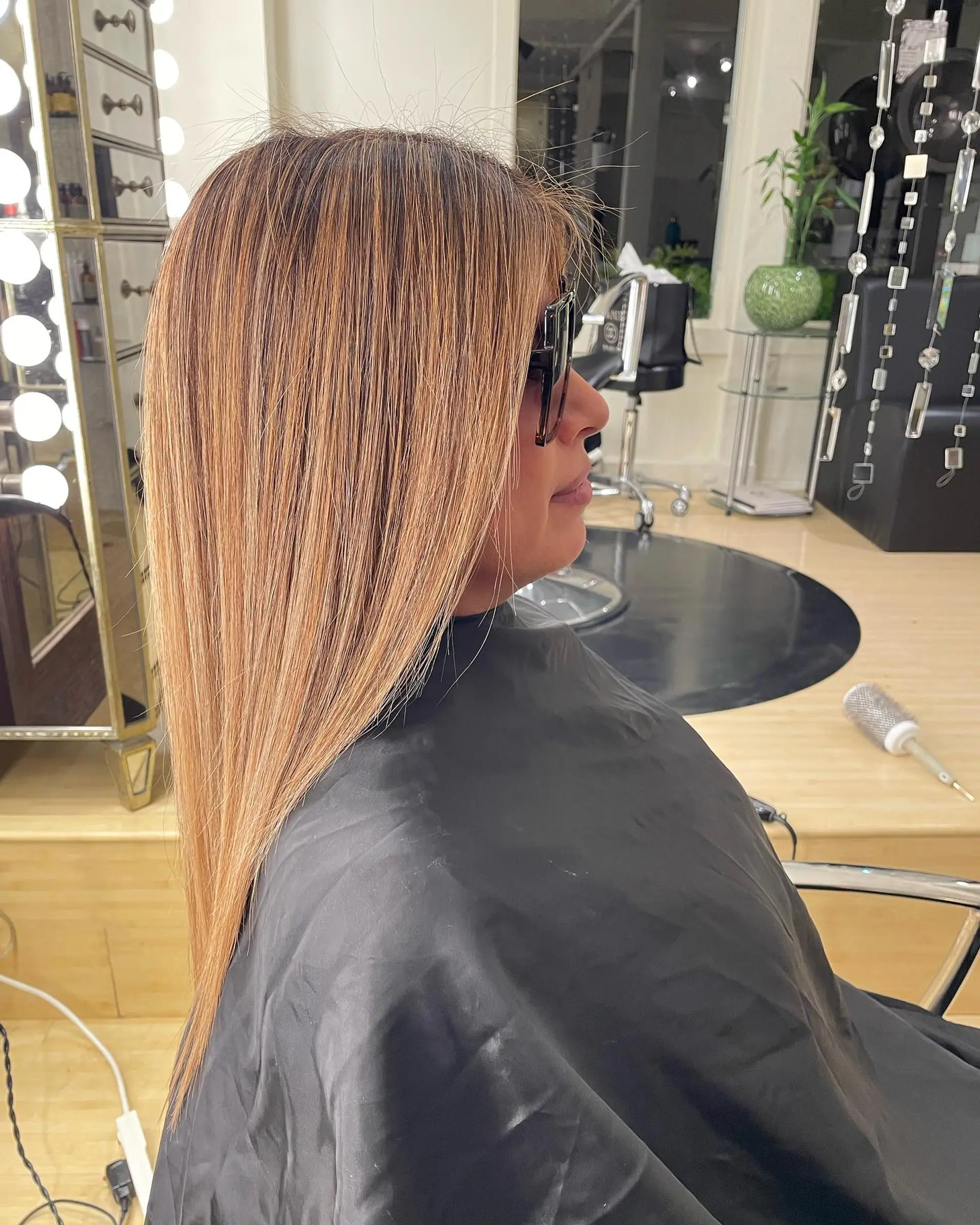 Long, pin-straight hair styled with warm honey blonde highlights and a smooth, glossy finish. 1