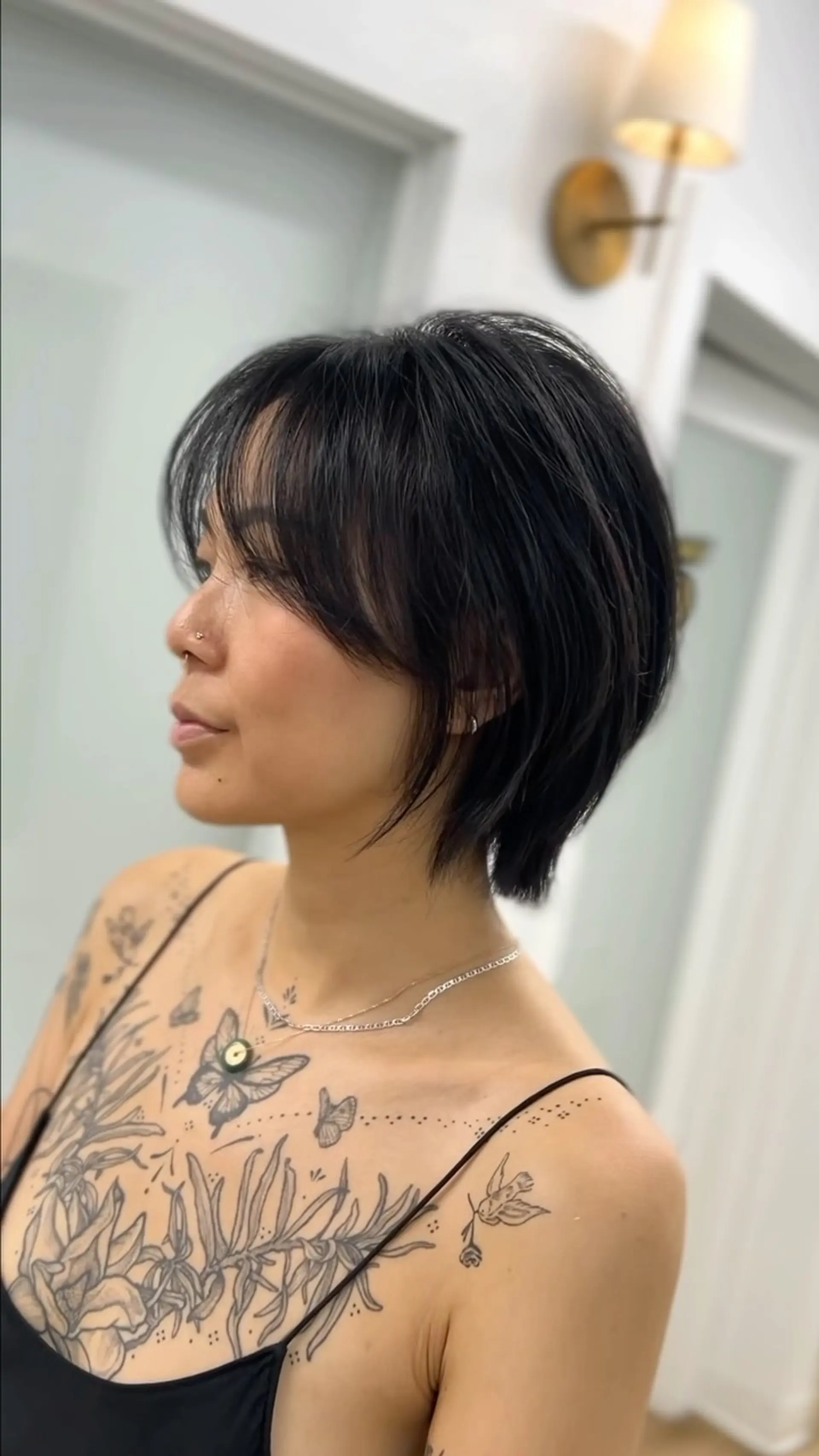 A textured short bixie cut featuring soft, wispy curtain bangs and tapered layers around the neck and jawline. 1