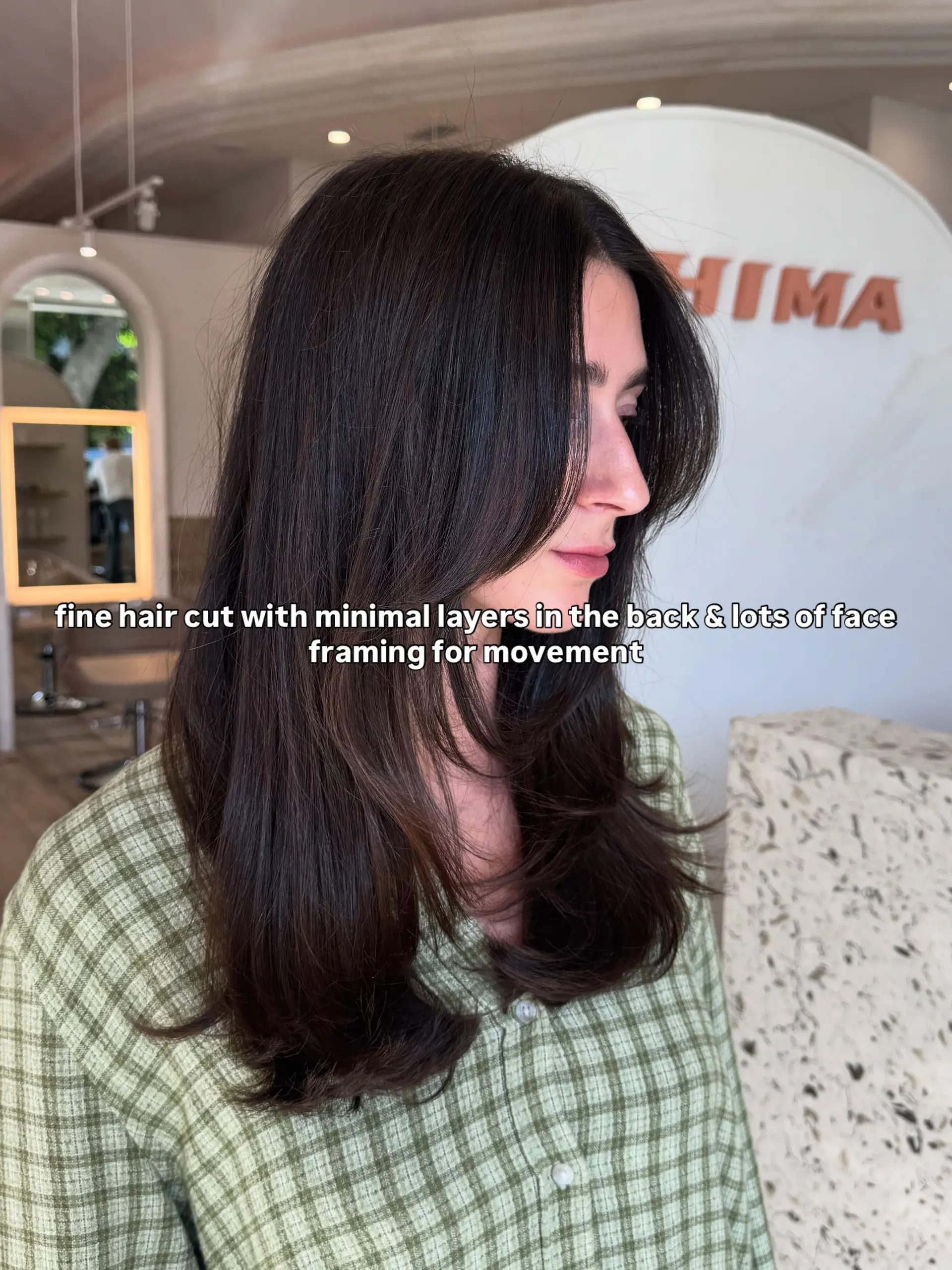 A long dark brunette haircut featuring subtle layering with feathered face-framing strands. 1