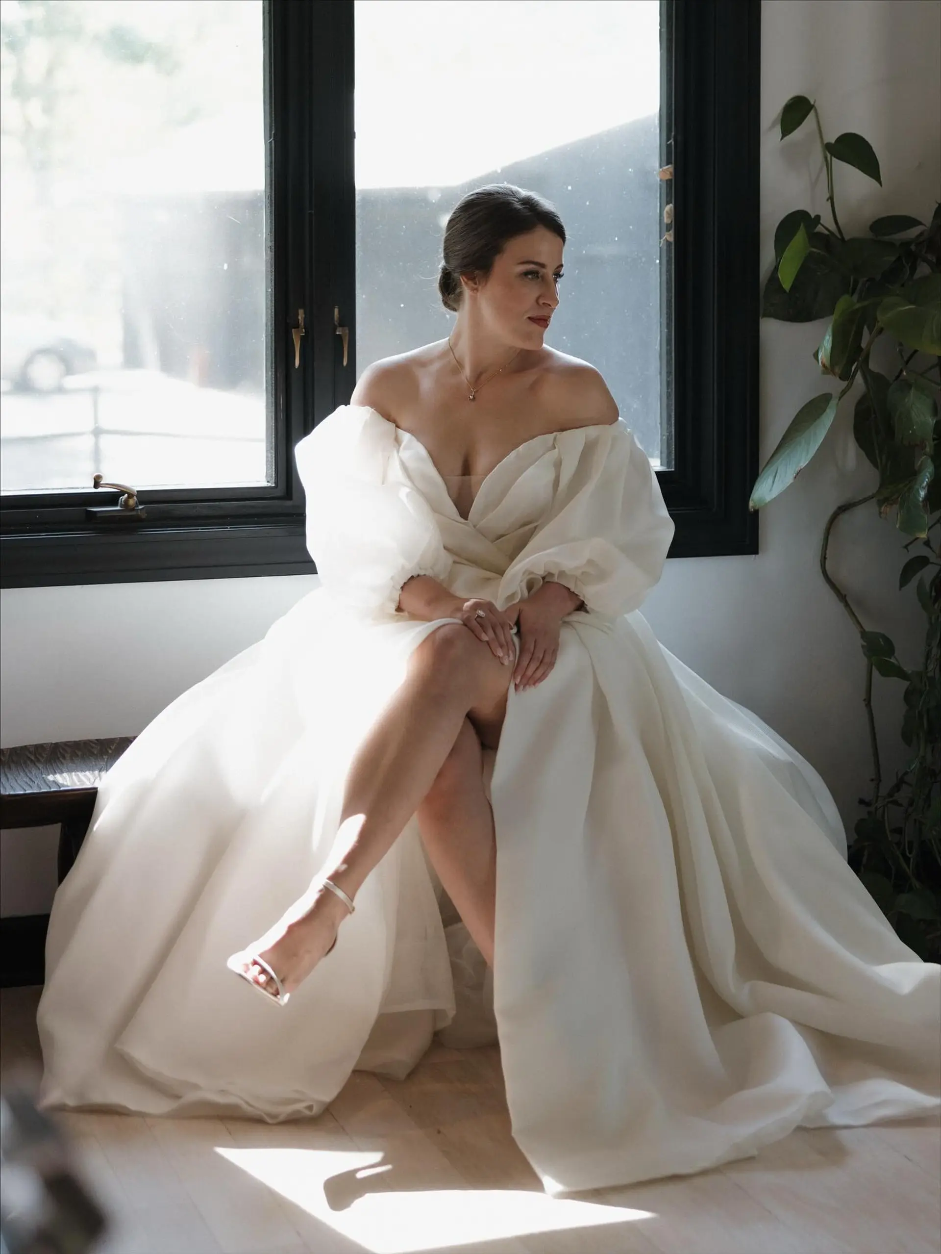 A sleek and elegant bridal updo gathered neatly into a smooth, low bun at the nape with soft volume at the crown. 1