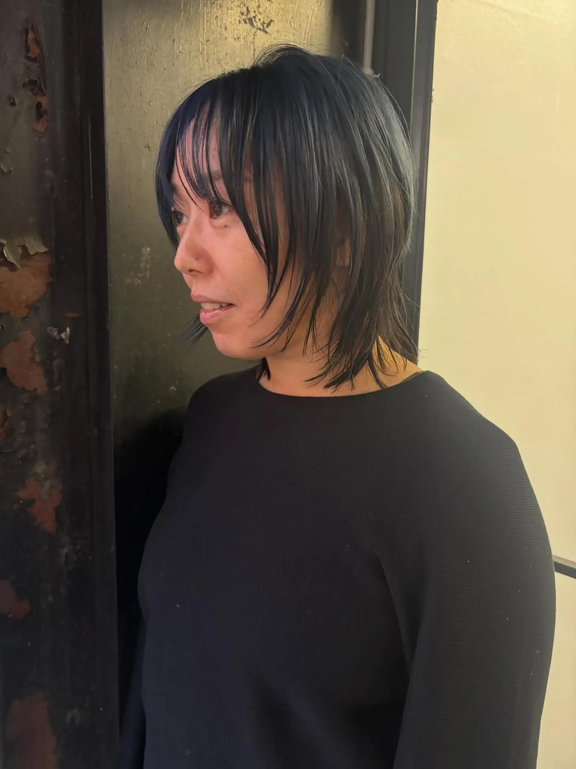 A layered, medium-length shaggy wolf cut characterized by wispy bangs, face-framing layers, and a textured, piecey finish. 1