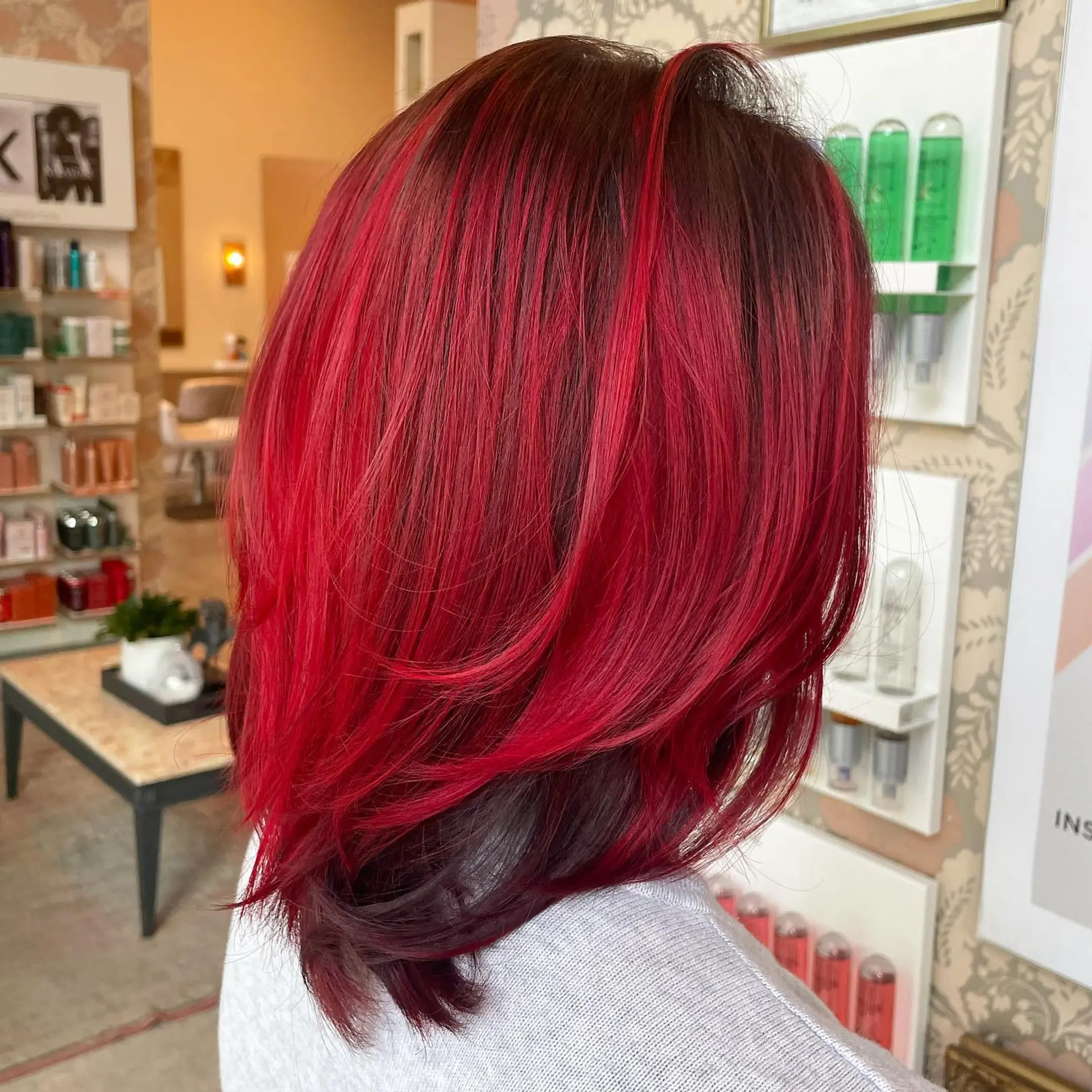 Vibrant crimson red layered medium-length hair with a dark contrasting underlayer, styled with smooth volume. 1
