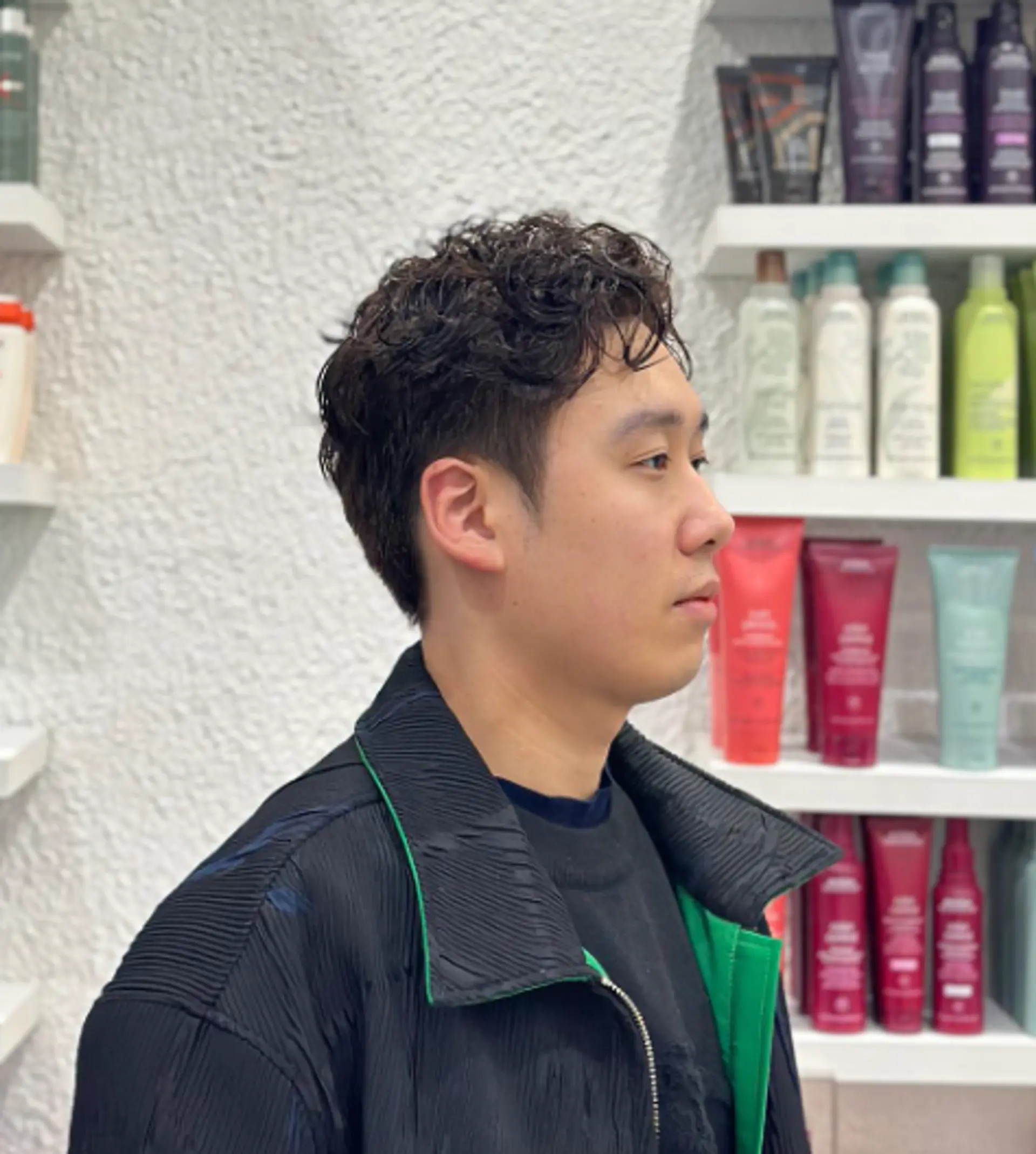 Neatly styled short haircut with a curly top, featuring a fade on the sides and a side part for a modern and sophisticated look. 1