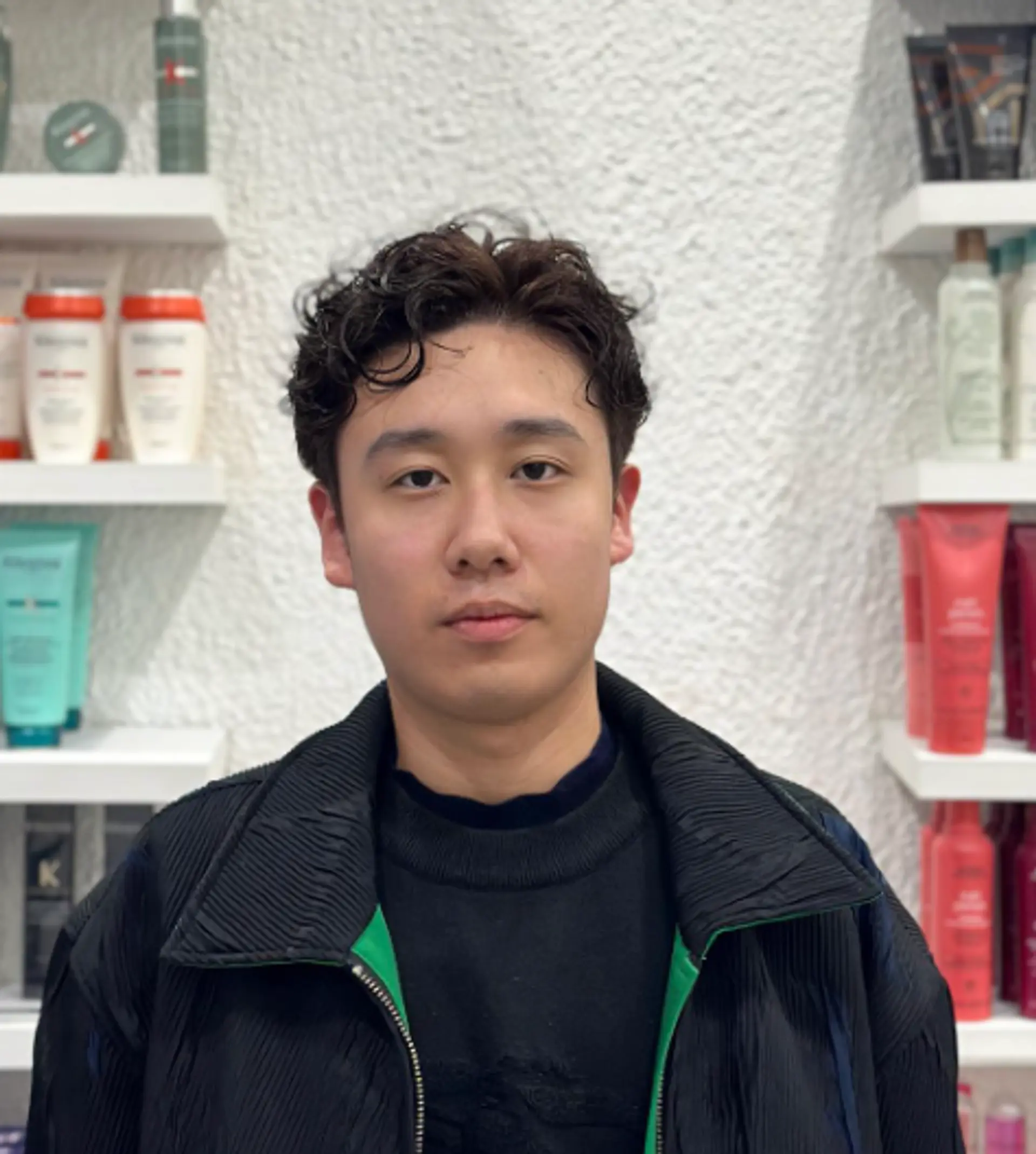 Neatly styled short haircut with a curly top, featuring a fade on the sides and a side part for a modern and sophisticated look. 2