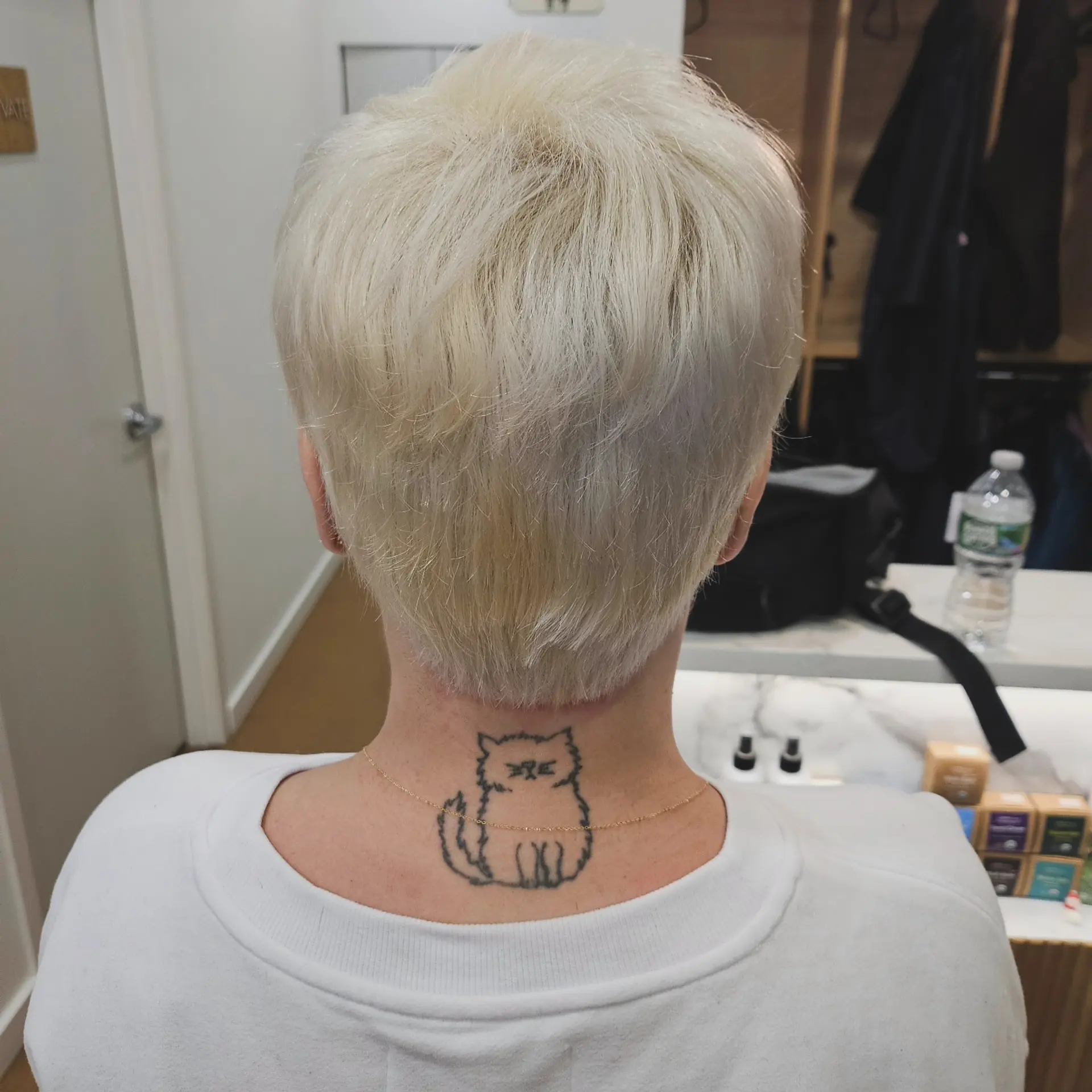 A short, softly textured platinum blonde pixie cut with a clean, tapered nape. 1