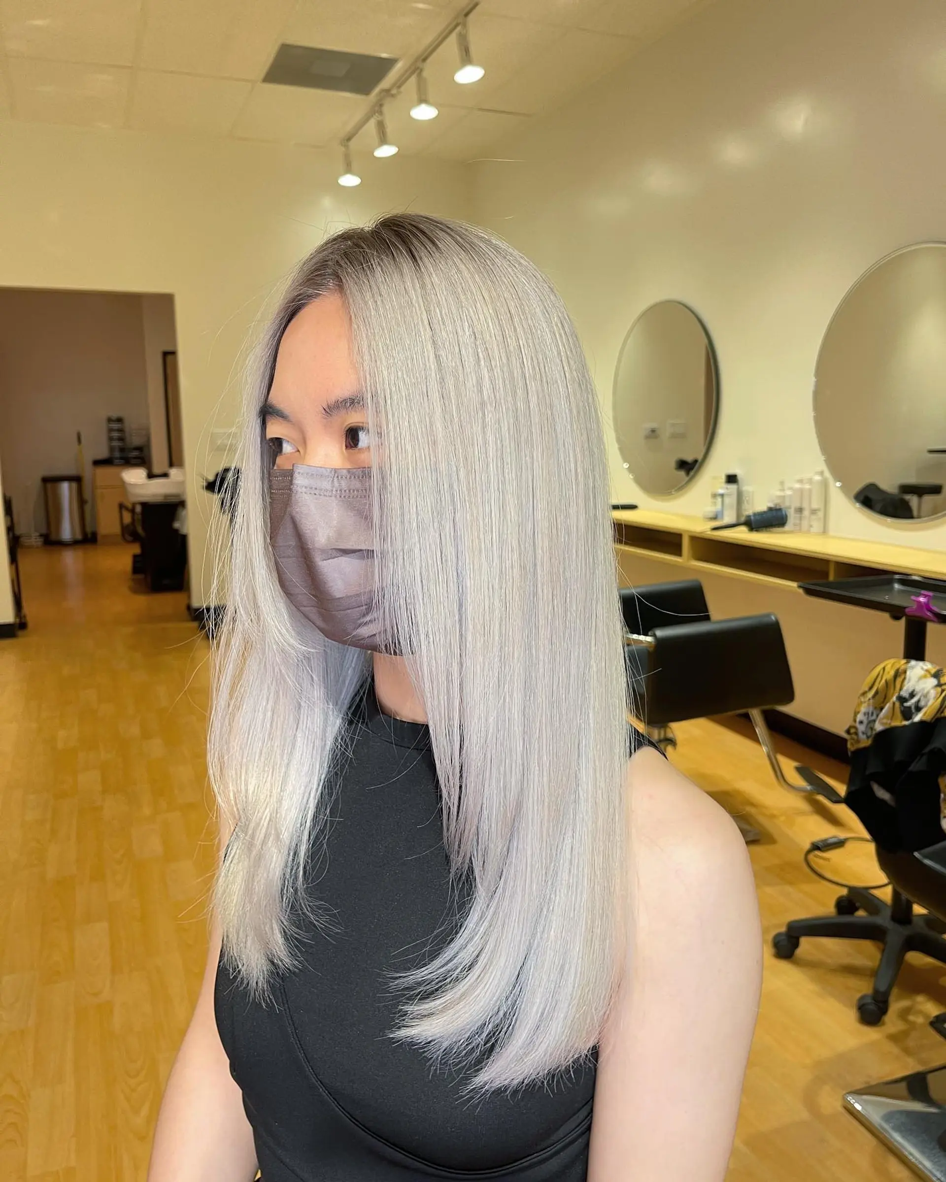 Sleek and straight long hair toned to an icy platinum silver with a subtle dark shadow root and gentle face-framing layers. 1