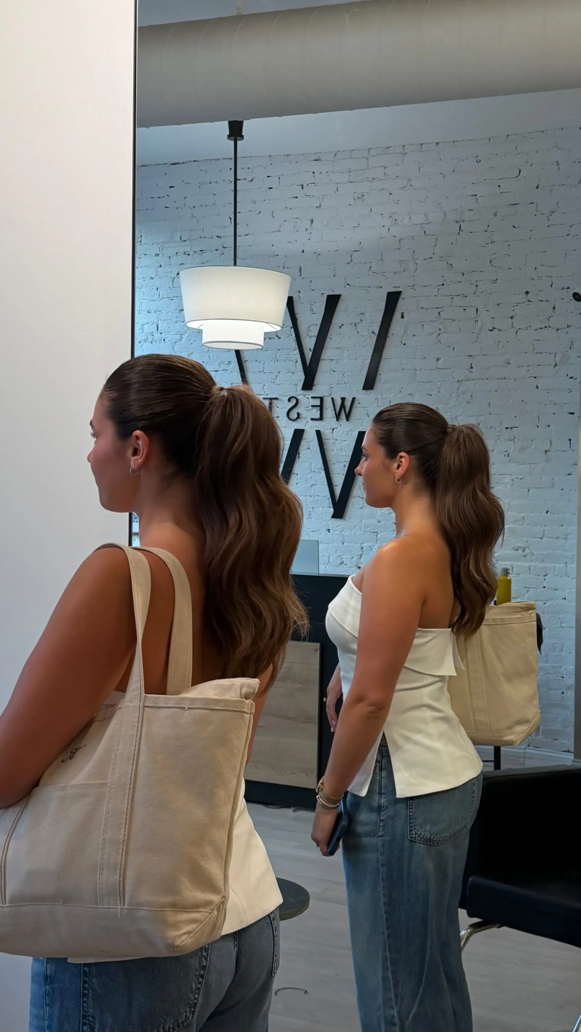 A sleek, slicked-back ponytail styled with defined, voluminous body waves. 1