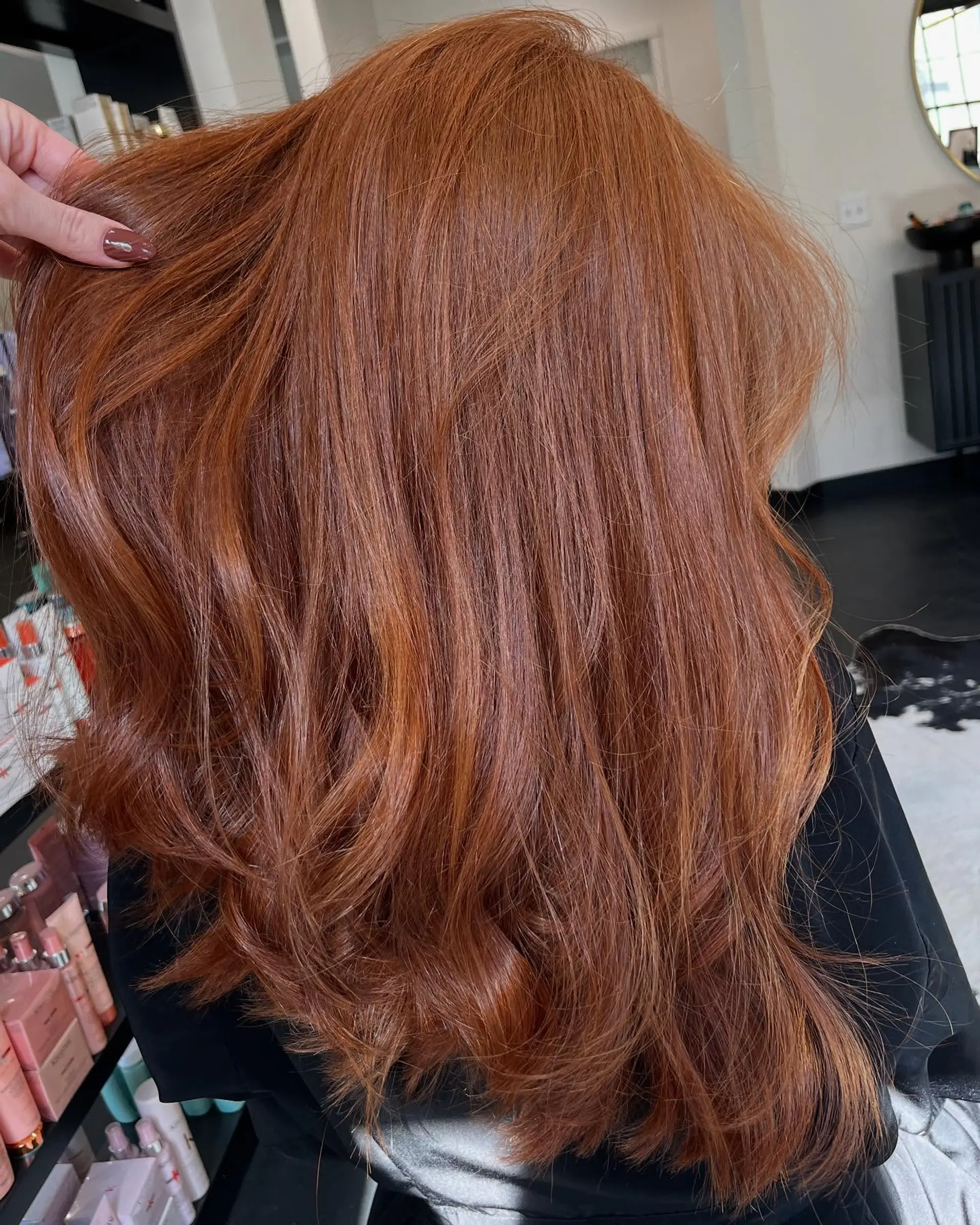 Vibrant warm copper hair with layered dimension and voluminous, soft blowout waves. 1