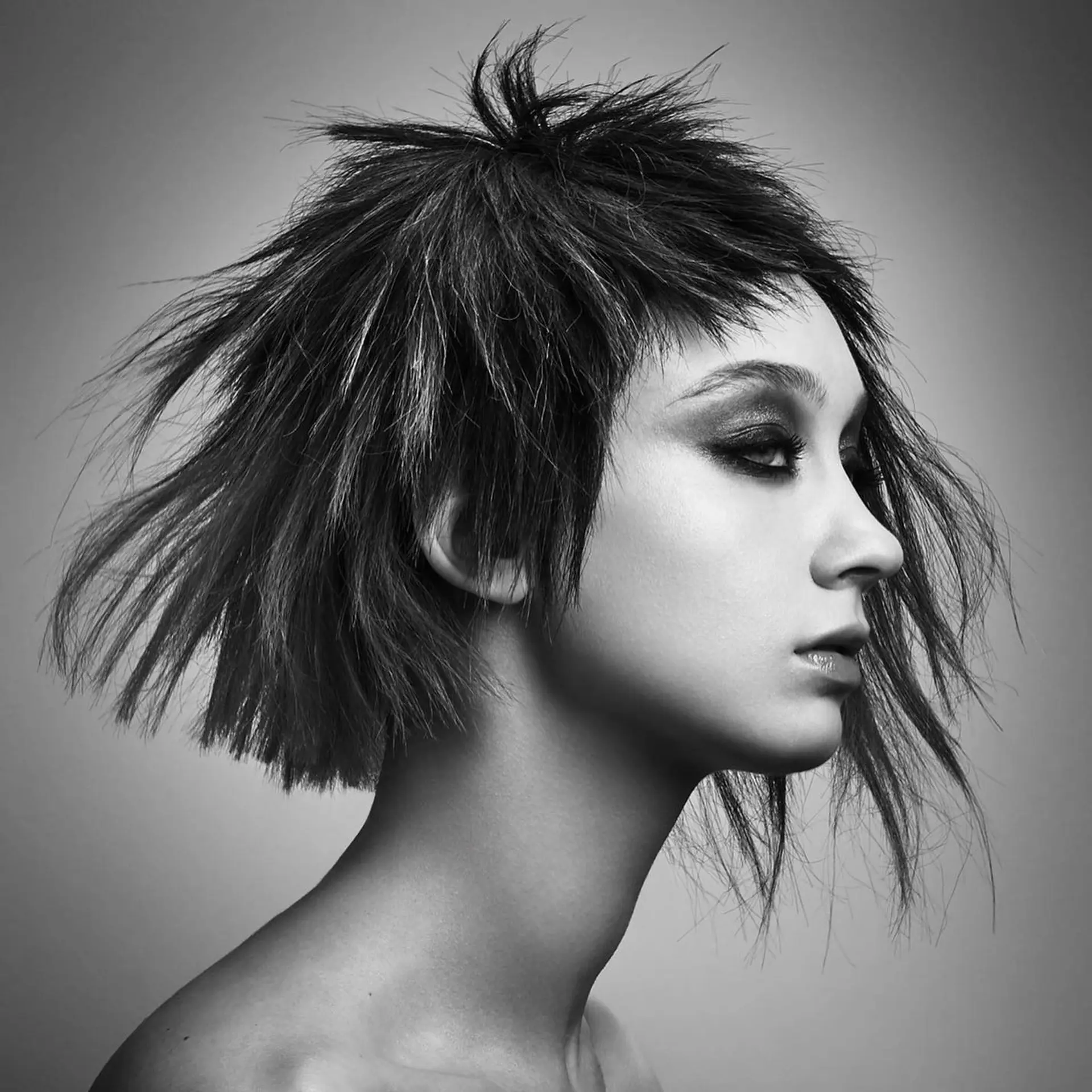 An avant-garde, heavily textured short bob featuring spiky layers and jagged micro bangs. 1