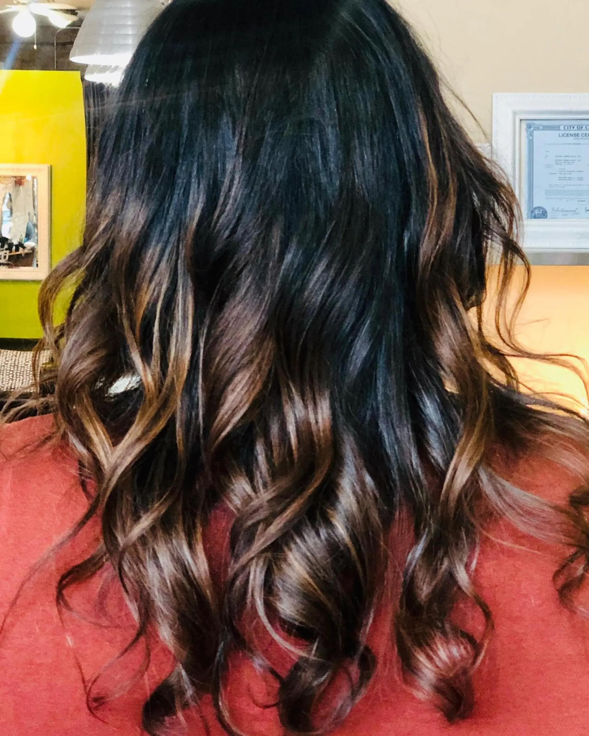 Long dark brown hair featuring blended caramel balayage highlights and styled with loose curls. 1