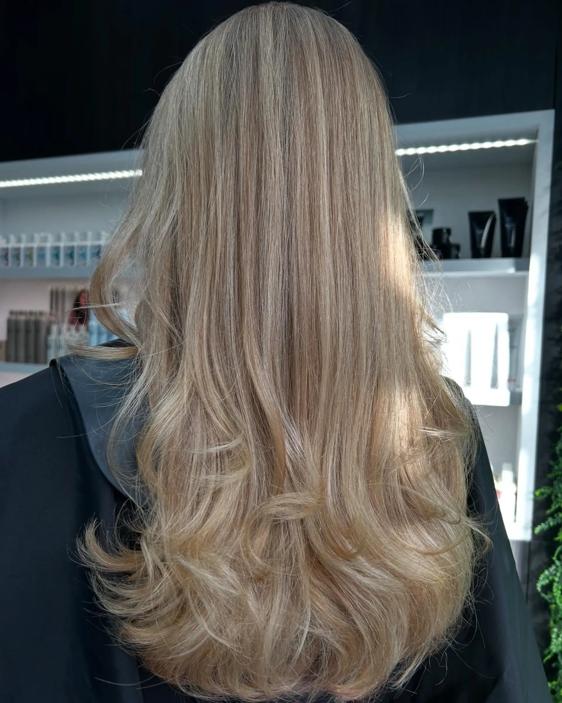 A long, straight hairstyle with flowy, wavy ends, complemented by a soft blonde balayage. 1
