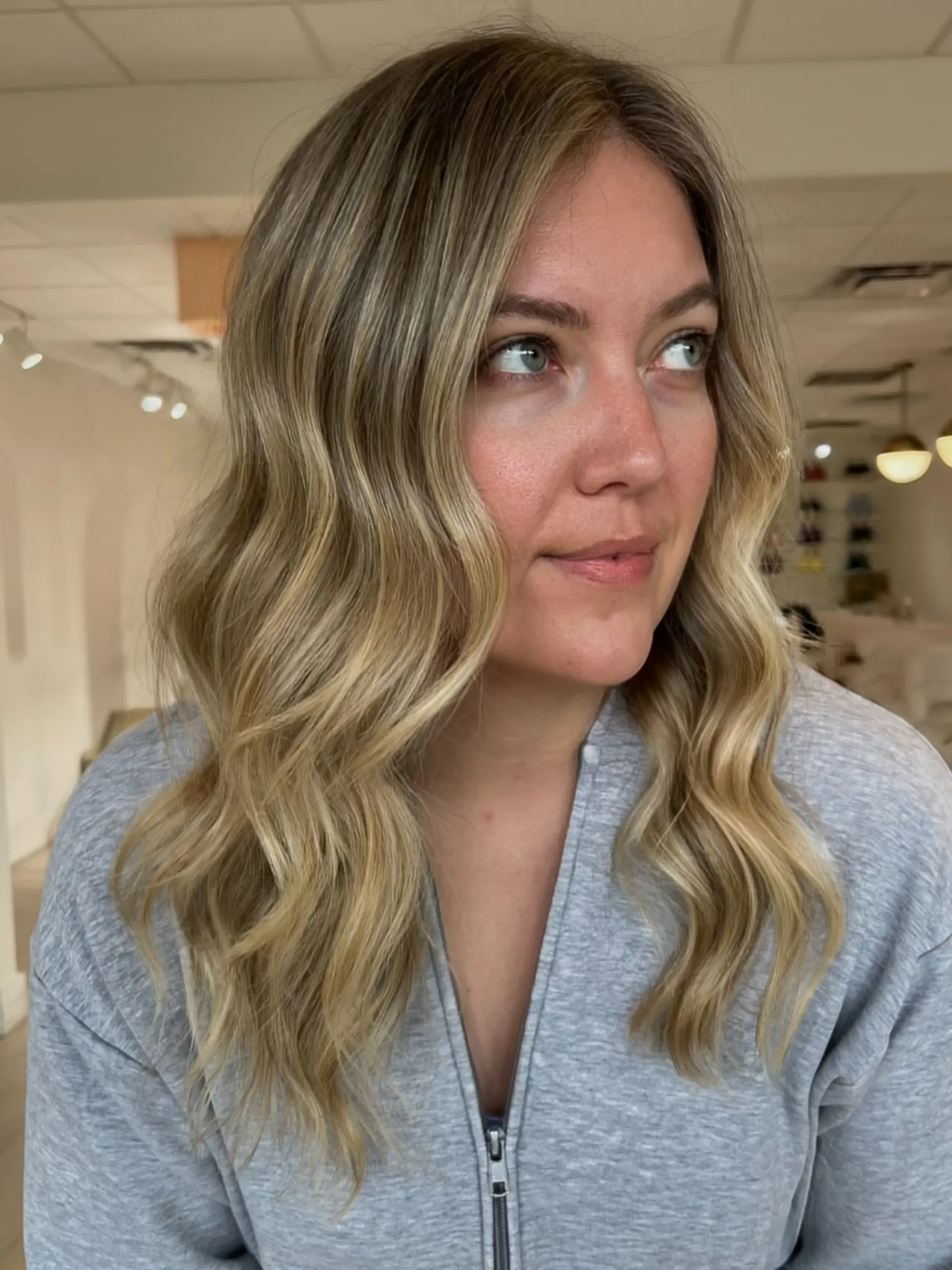 Medium-to-long dimensional blonde hair styled into soft, loose waves with bright face-framing pieces. 1