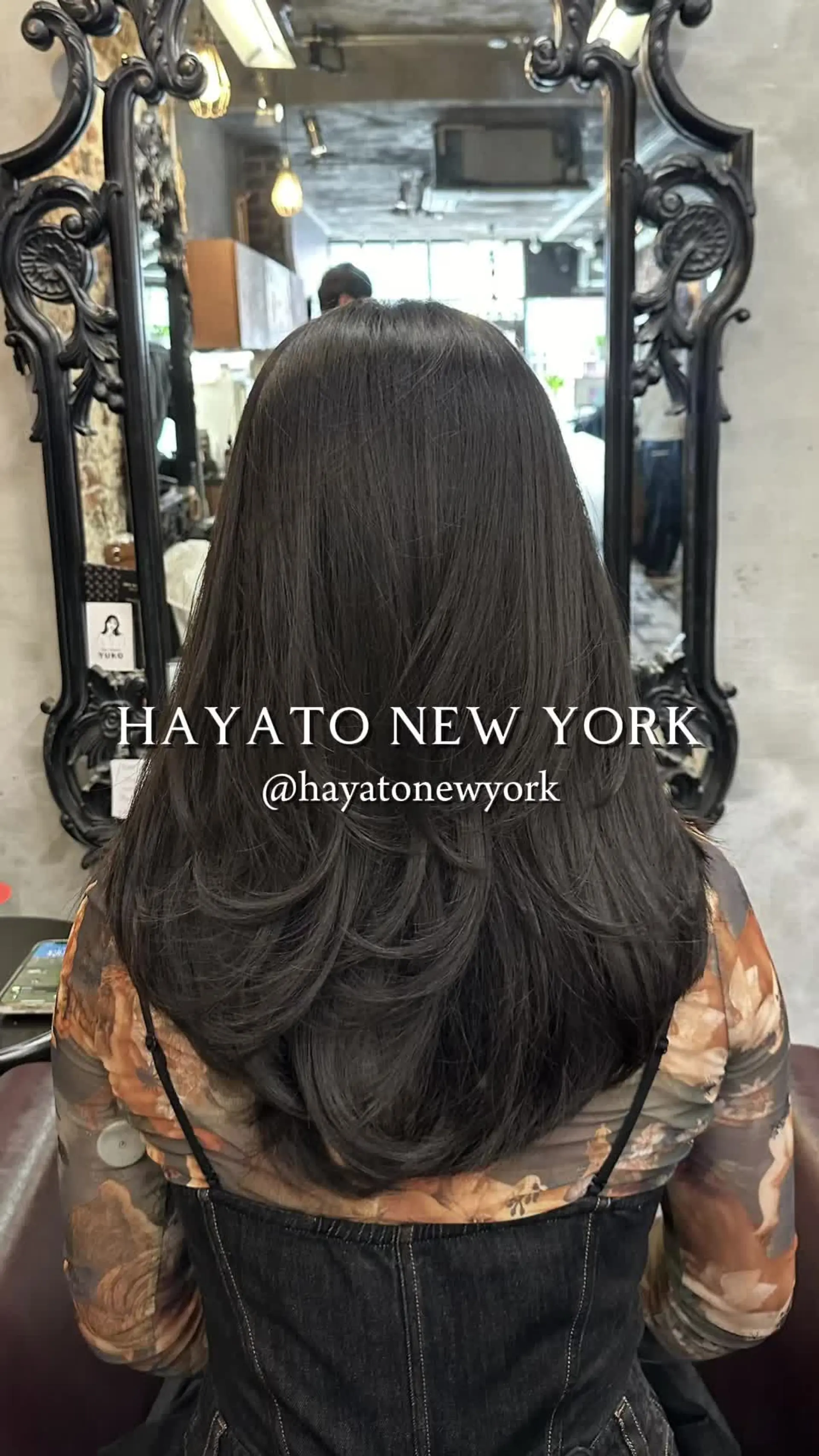 A long, smooth dark brunette haircut styled with multi-tiered layers curving inward toward the center back. 1