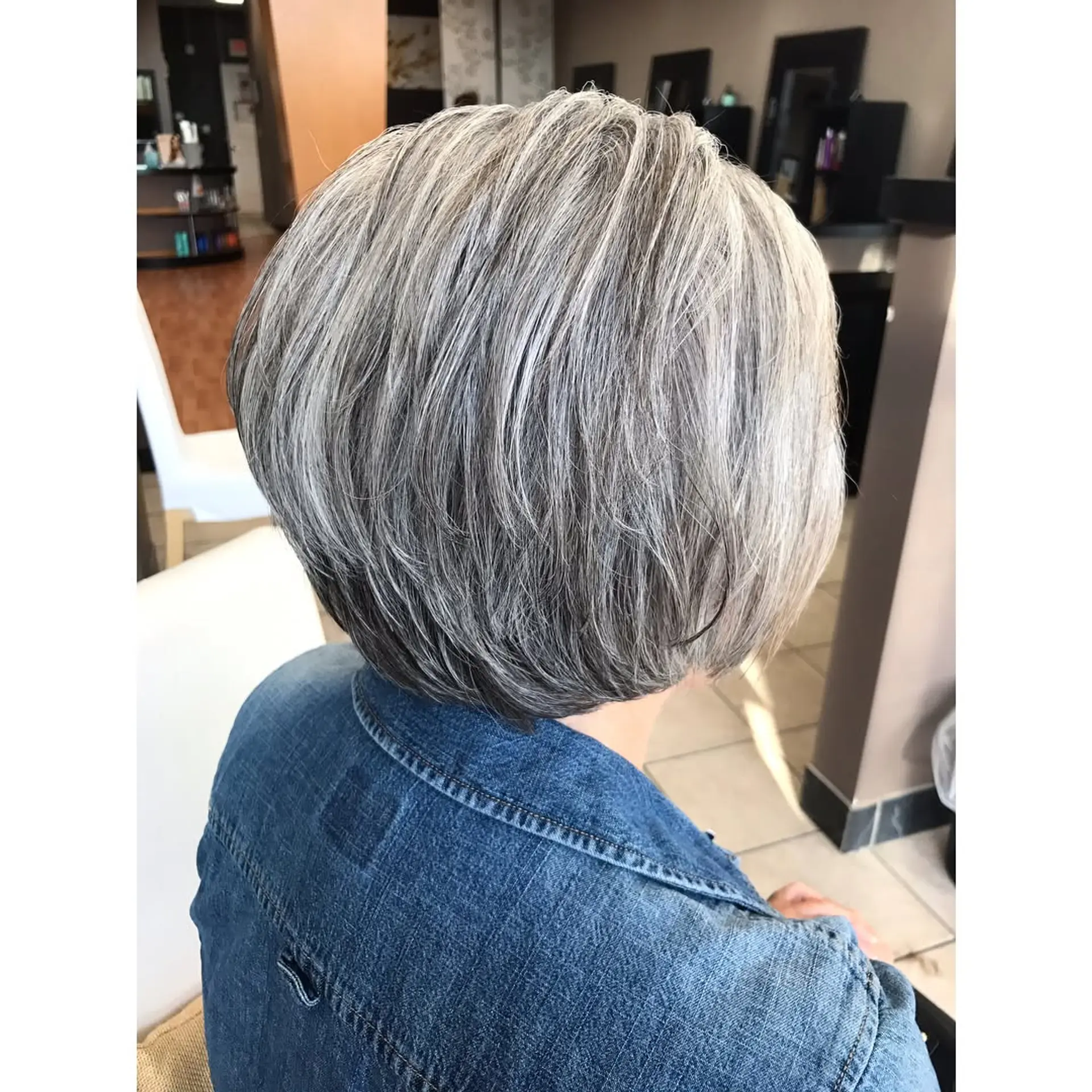 A rounded short bob haircut with soft texturized layers in a multi-tonal sparkling silver hue. 1