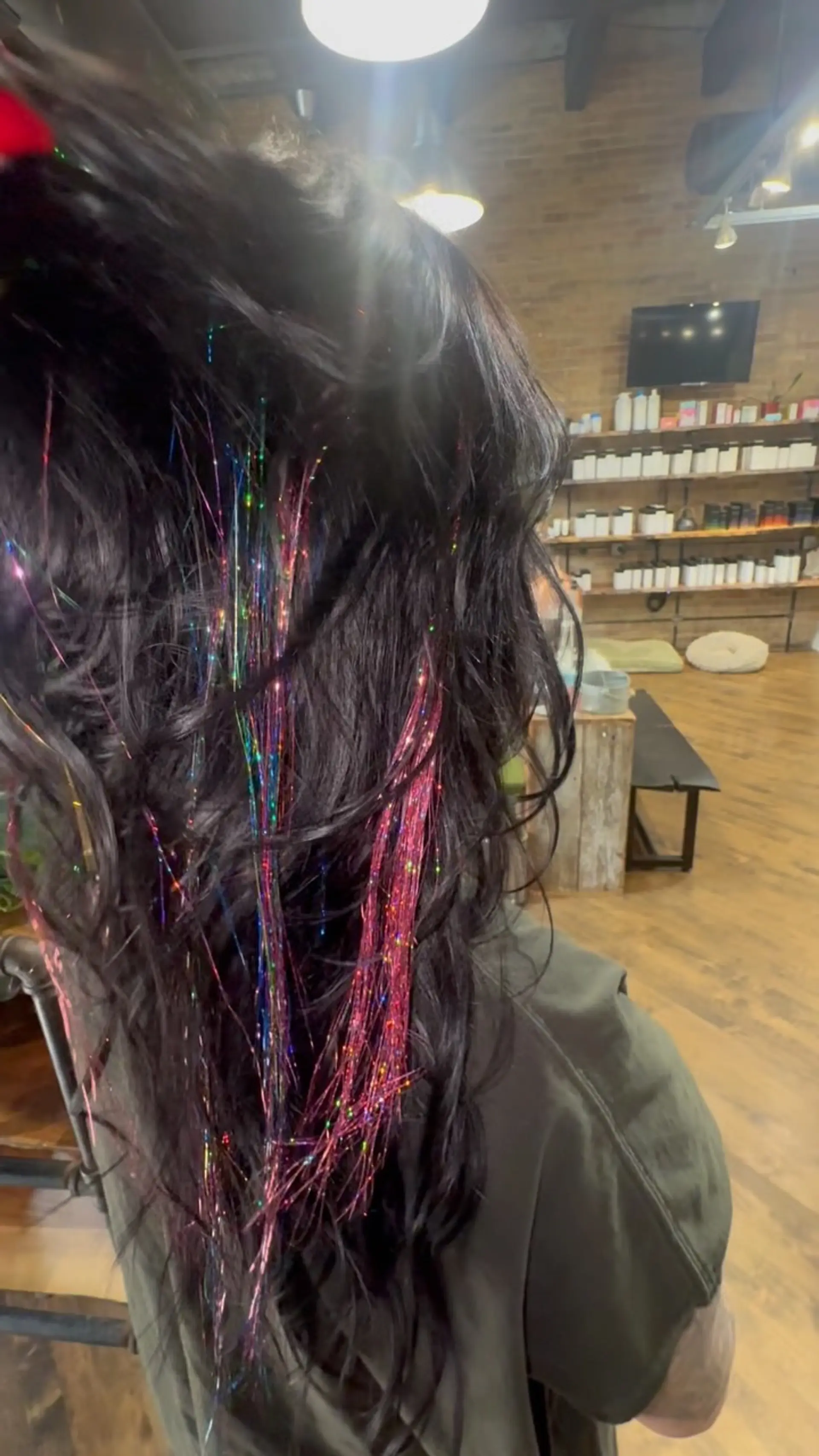Long, tousled dark waves adorned with vibrant, shimmering strands of multi-colored hair tinsel. 1