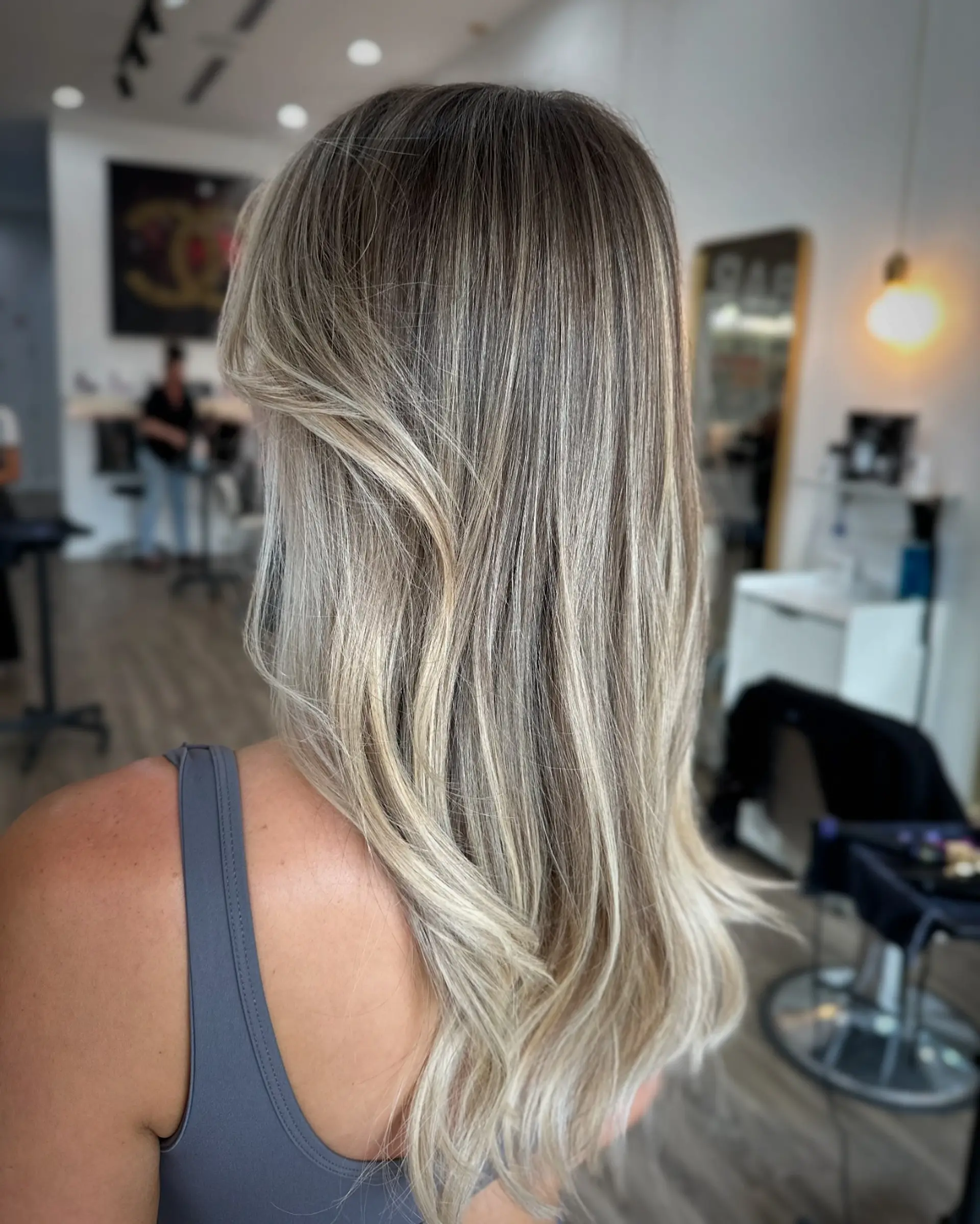 A stunning layered haircut with face-framing layers and curtain bangs, styled with soft beachy waves. 2