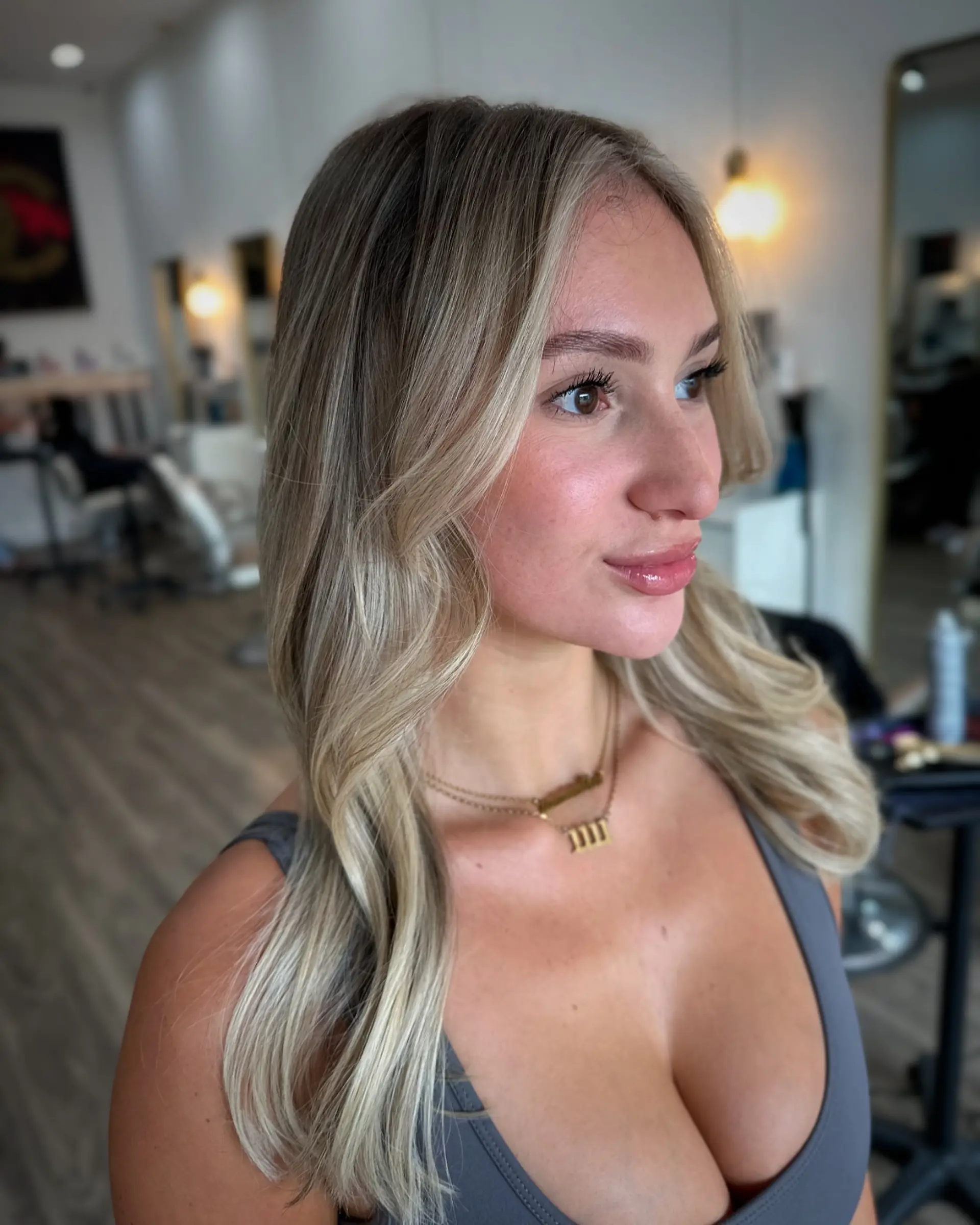 A stunning layered haircut with face-framing layers and curtain bangs, styled with soft beachy waves. 3