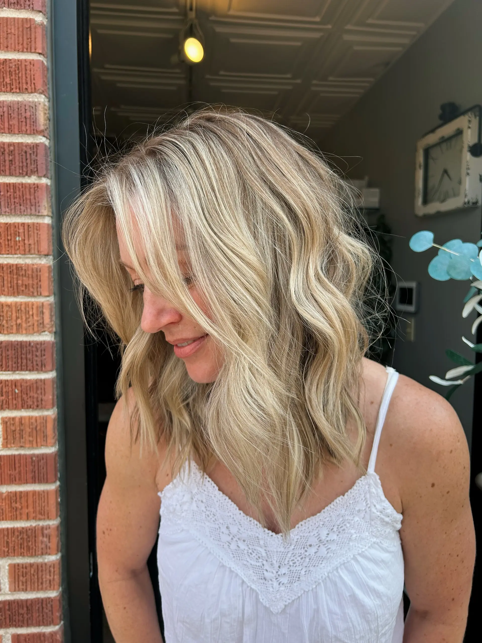 A textured medium-length lob featuring dimensional blonde highlights styled in loose, lived-in waves. 1