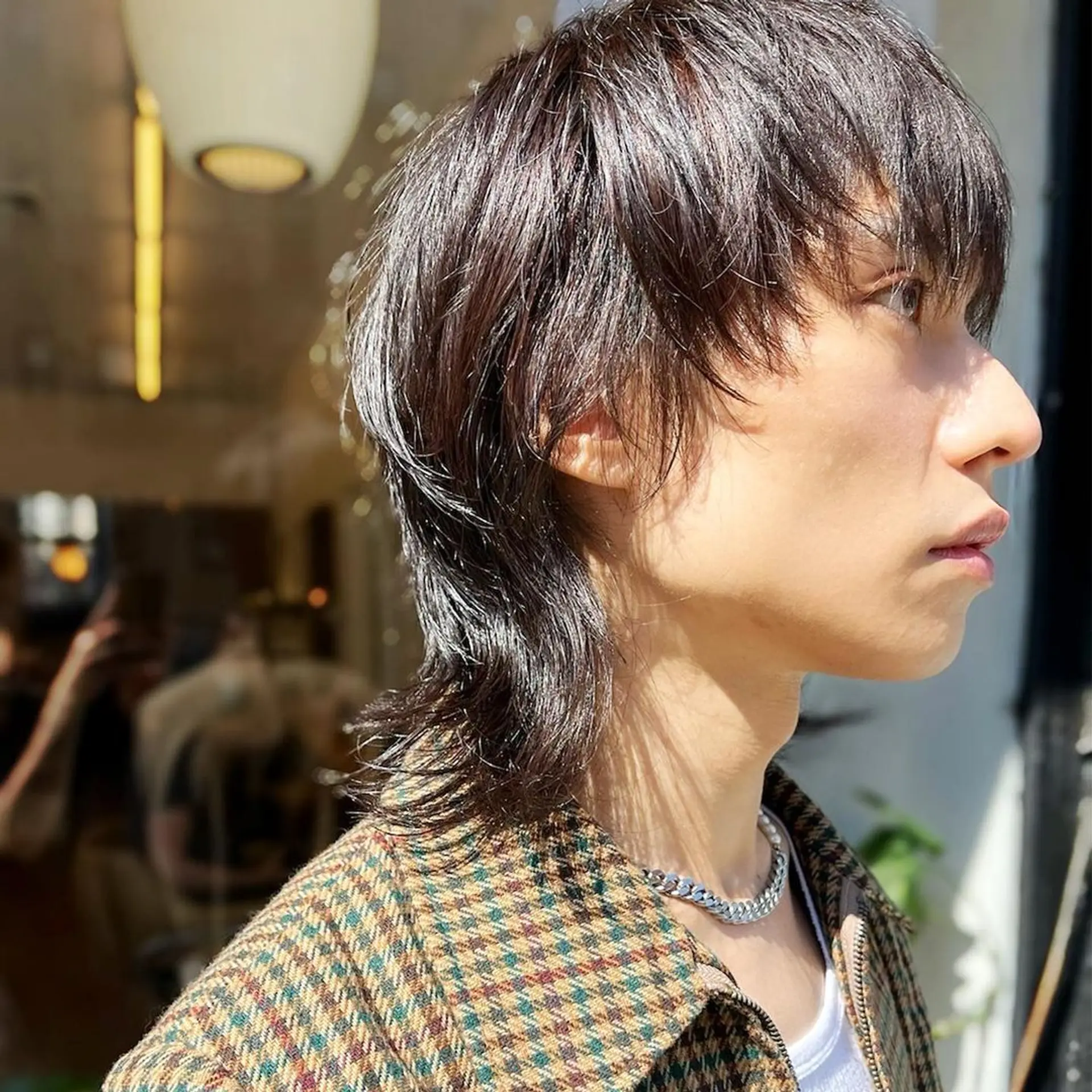 Dark brown, medium-length hair styled in an edgy modern mullet with layered, wavy texture and tapered sides. haircut by @kotarohair.newyork 2