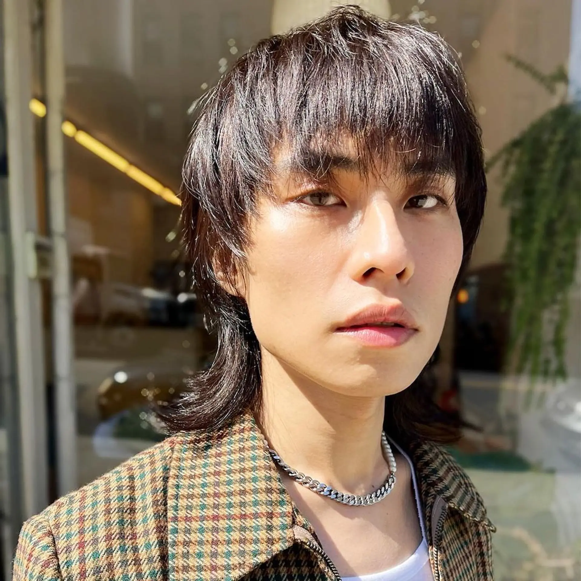 Dark brown, medium-length hair styled in an edgy modern mullet with layered, wavy texture and tapered sides. haircut by @kotarohair.newyork 1