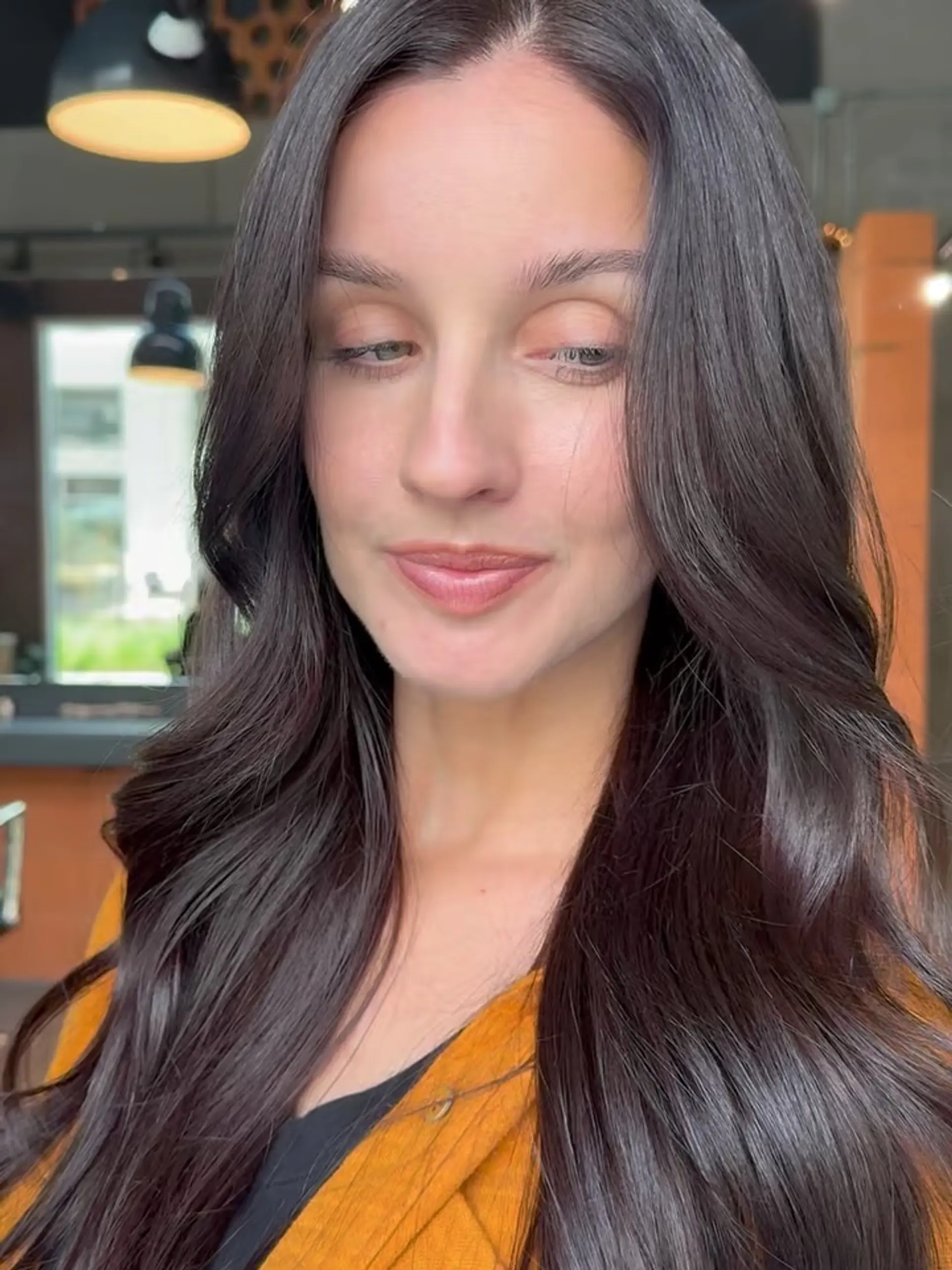 Long, glossy espresso brunette hair styled with smooth, loose waves and a clean center part. 1