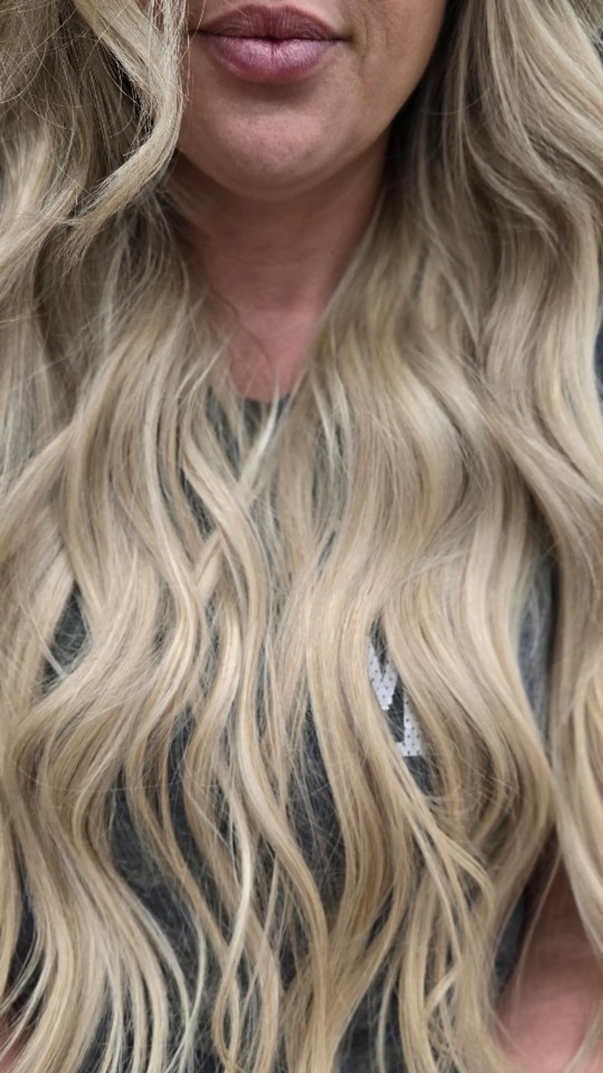 Long, flowing blonde hair styled in relaxed, loose waves cascading over the shoulders. 1