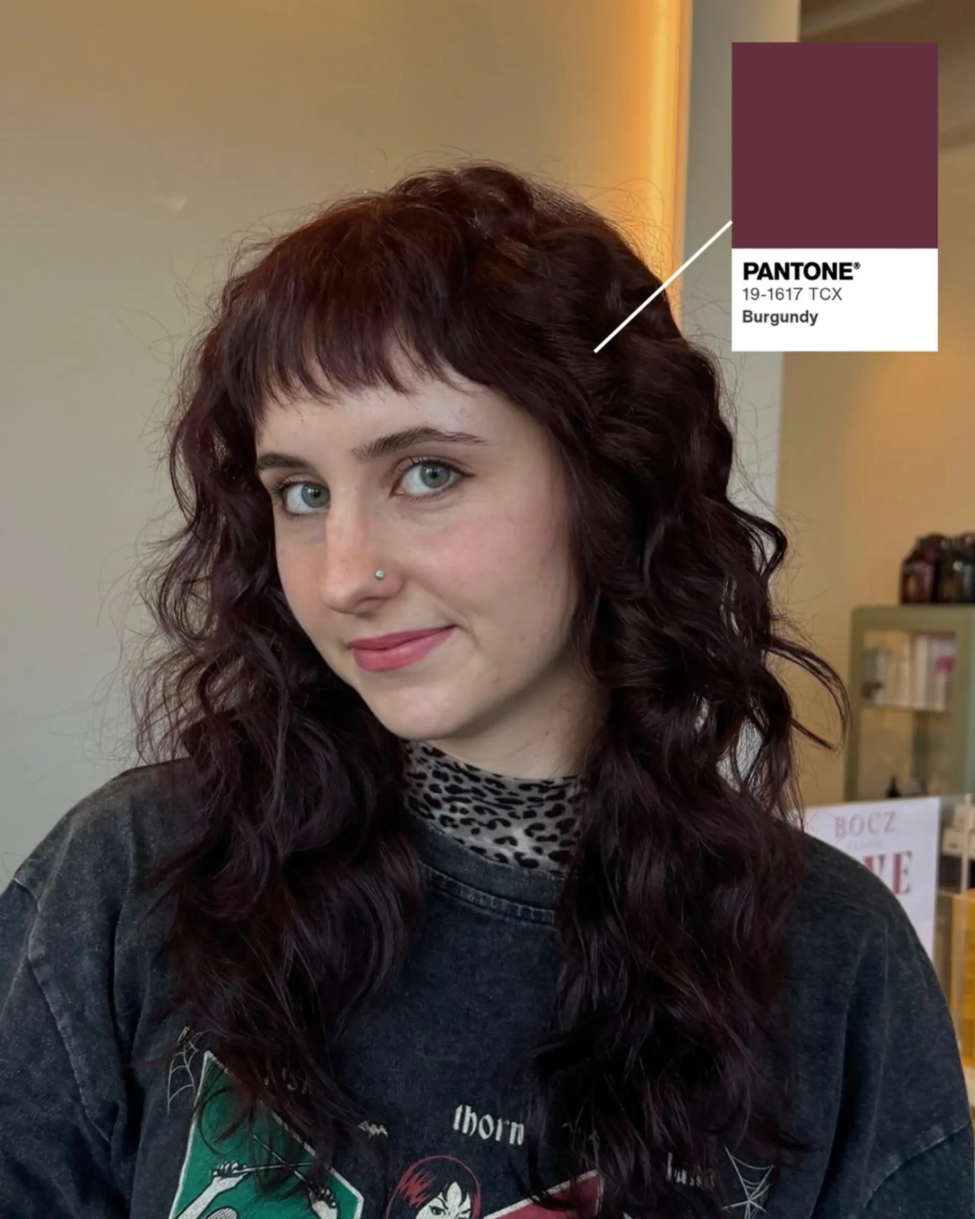Rich burgundy long hair styled in loose tousled waves with feathered baby bangs. 1