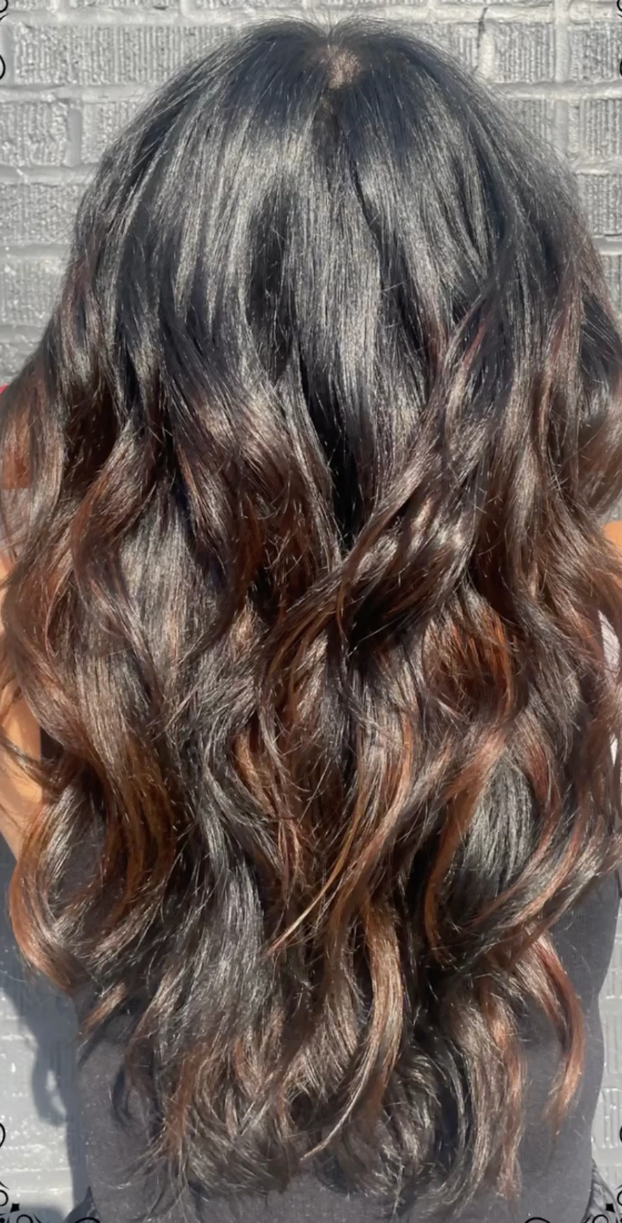Long wavy hair with black and bronze highlights, featuring voluminous, loose waves.
