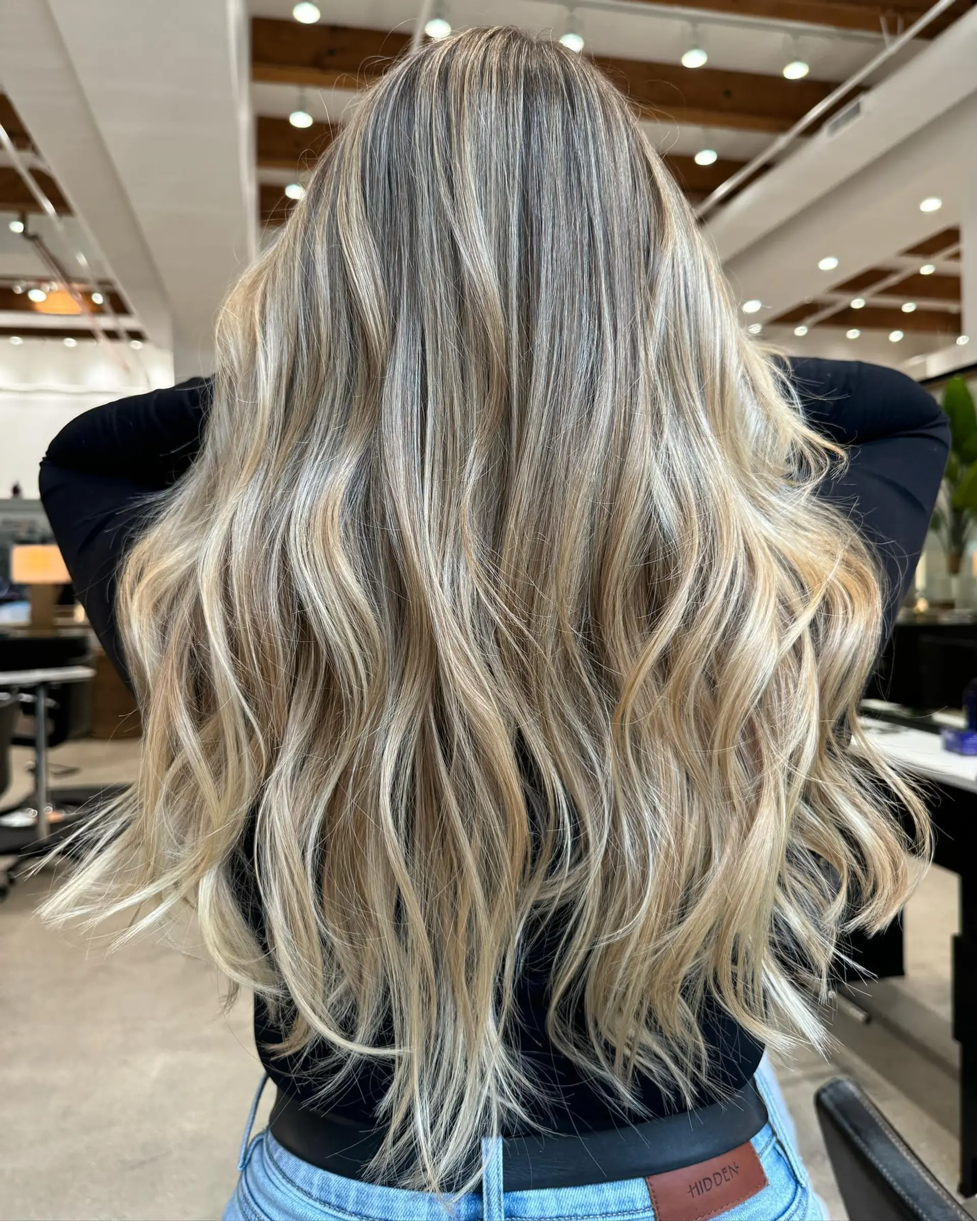 Long wavy hairstyle with a balayage color technique, creating a blend of blonde shades and a dimensional look. 1