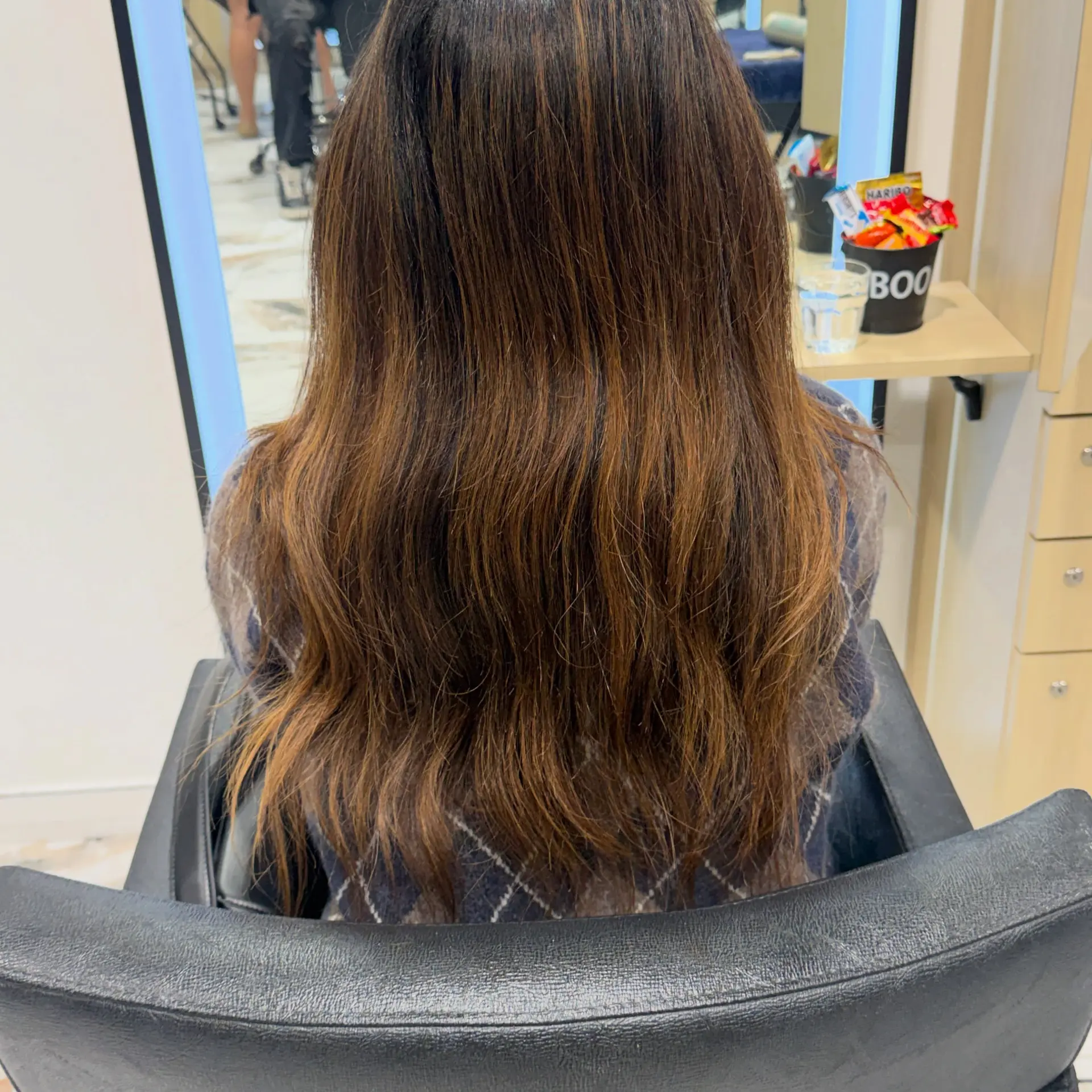 Long cool-toned brunette hair featuring subtle, natural-looking highlights and soft textured waves. 1