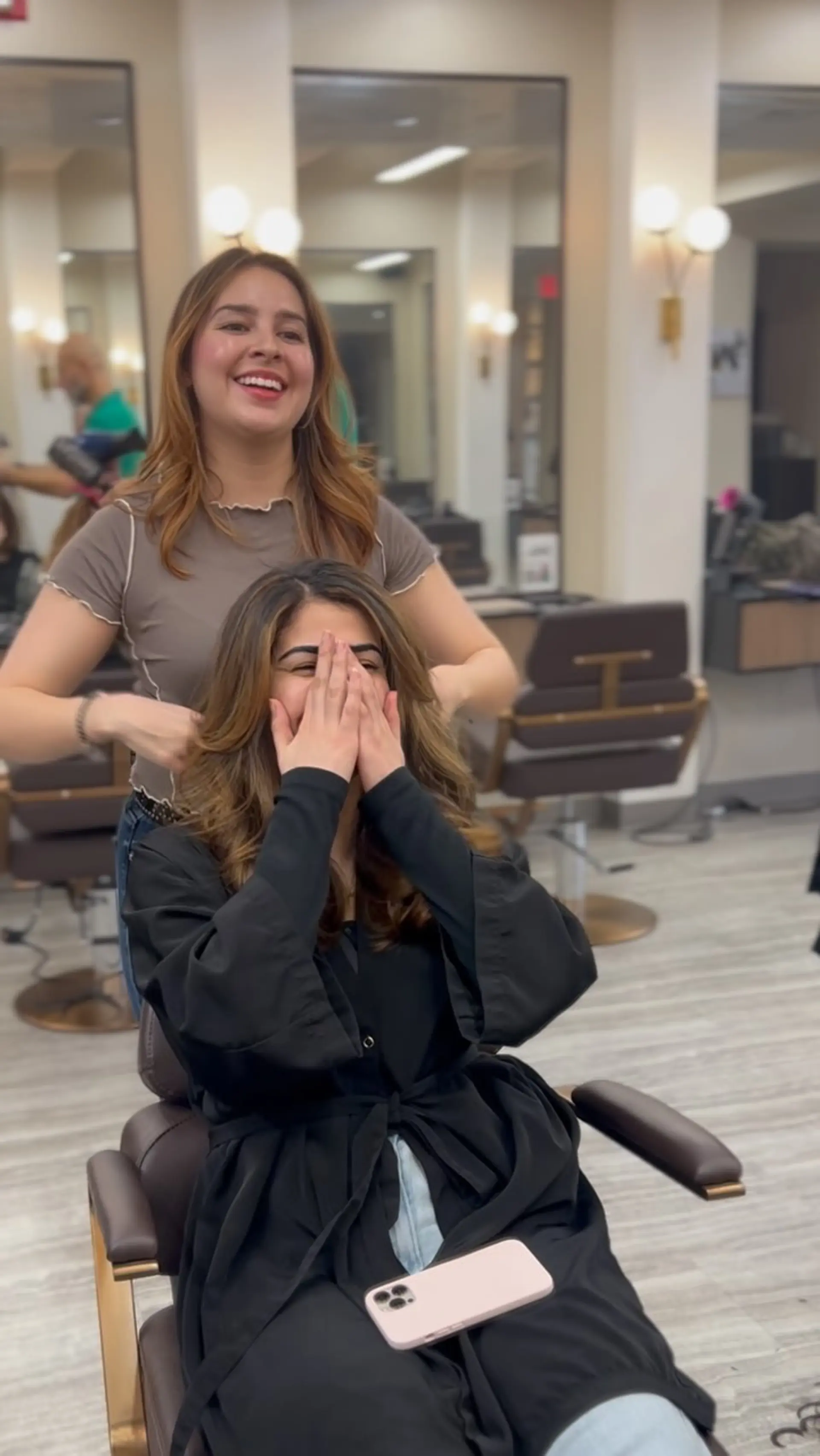 Long brunette hair with warm caramel balayage highlights styled in bouncy, voluminous blowout waves. 1