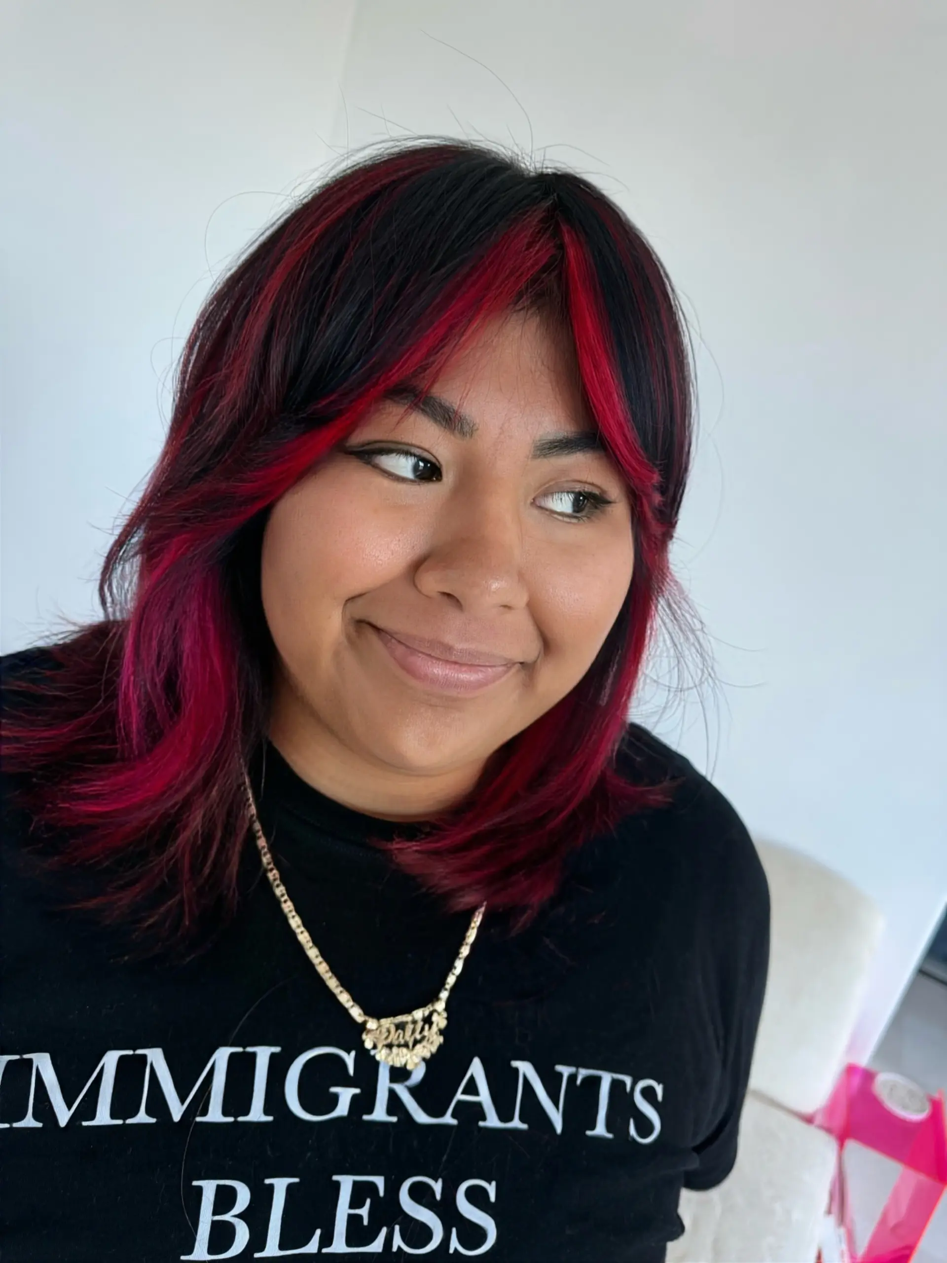 Medium-length dark hair with vibrant magenta face-framing bangs and layered ends. 1