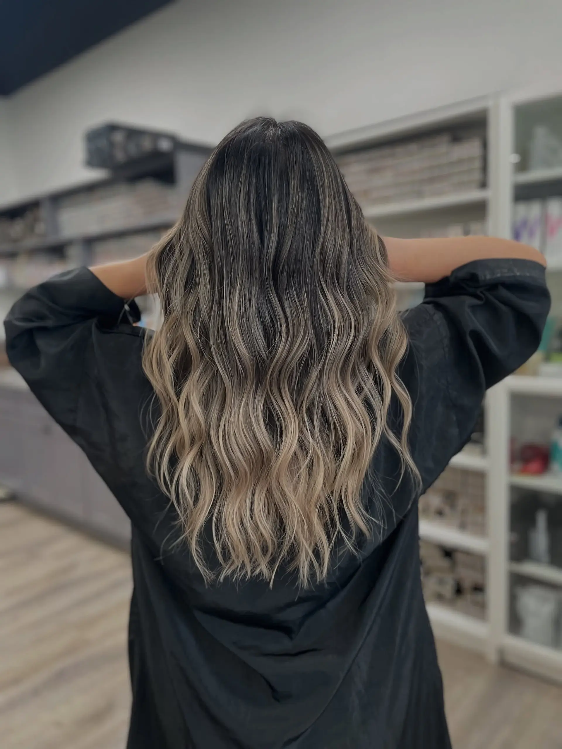 A long, wavy hairstyle with a dark to blonde balayage. 1