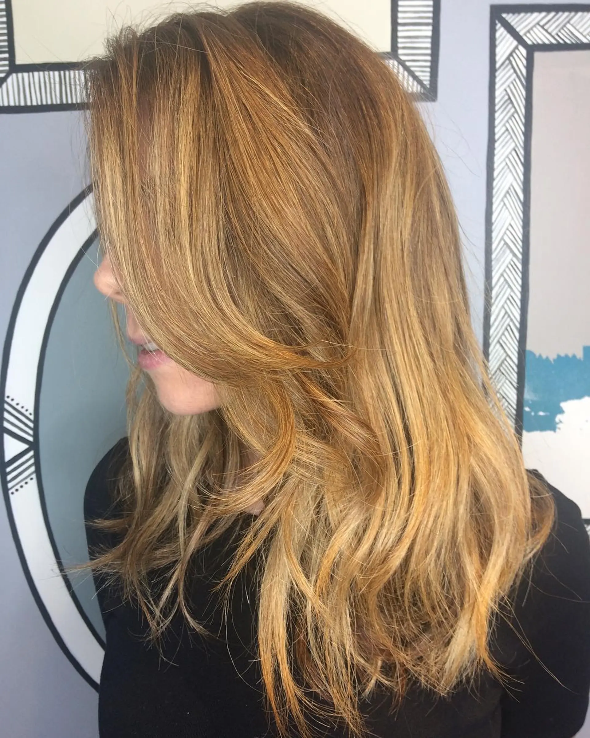 Long wavy hairstyle with caramel blonde balayage and face-framing layers. 1